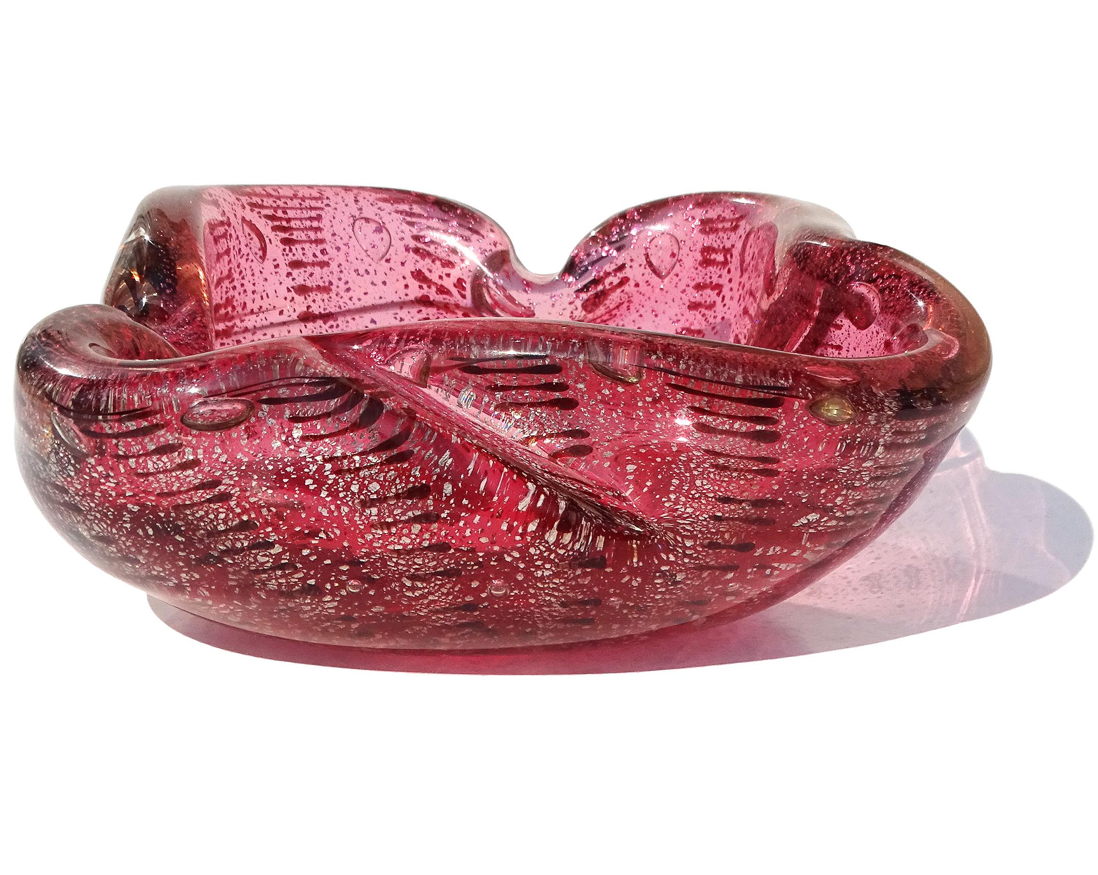 Beautiful vintage Murano hand blown, rich pink with dark spots Italian art glass decorative bowl. The piece has a biomorphic abstract shape, with decorative folds and indents. The bowl is profusely covered in silver leaf throughout, with rows of