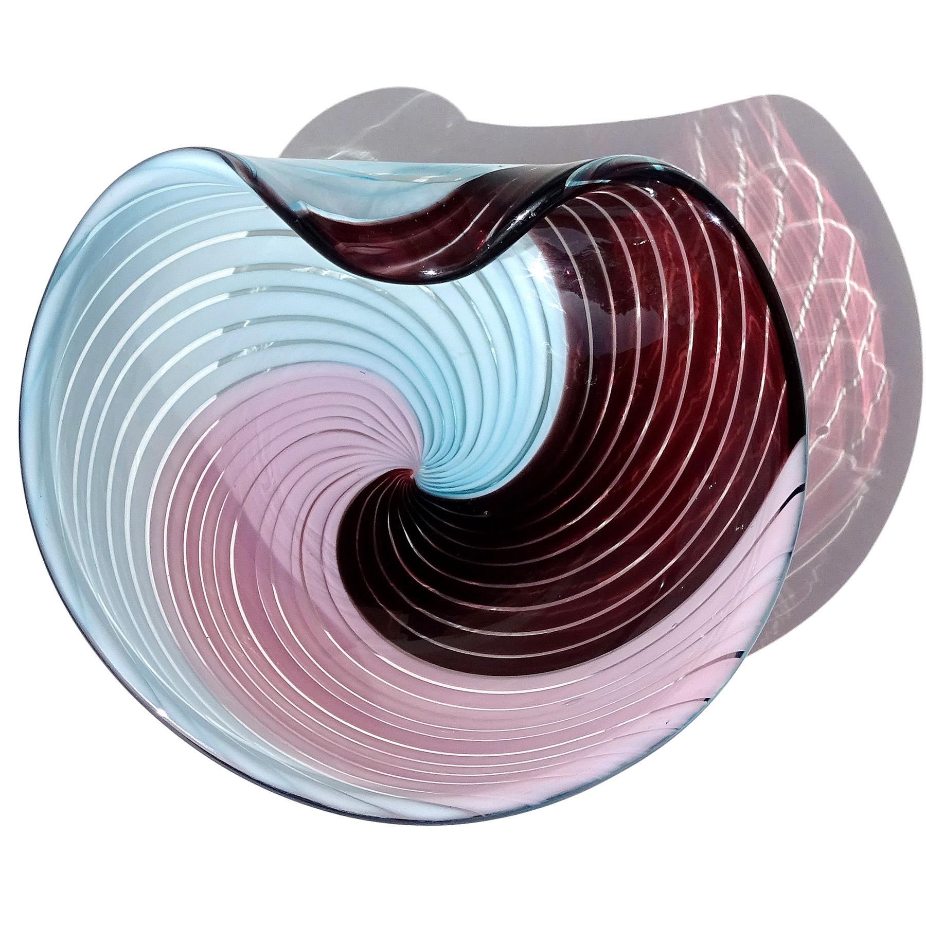 Beautiful and rare, vintage Murano hand blown pink, sky blue, dark purple ribbons Italian art glass decorative bowl. Created in the manner of designer Dino Martens for Aureliano Toso. The piece has an optic swirl pattern in alternating colors, with