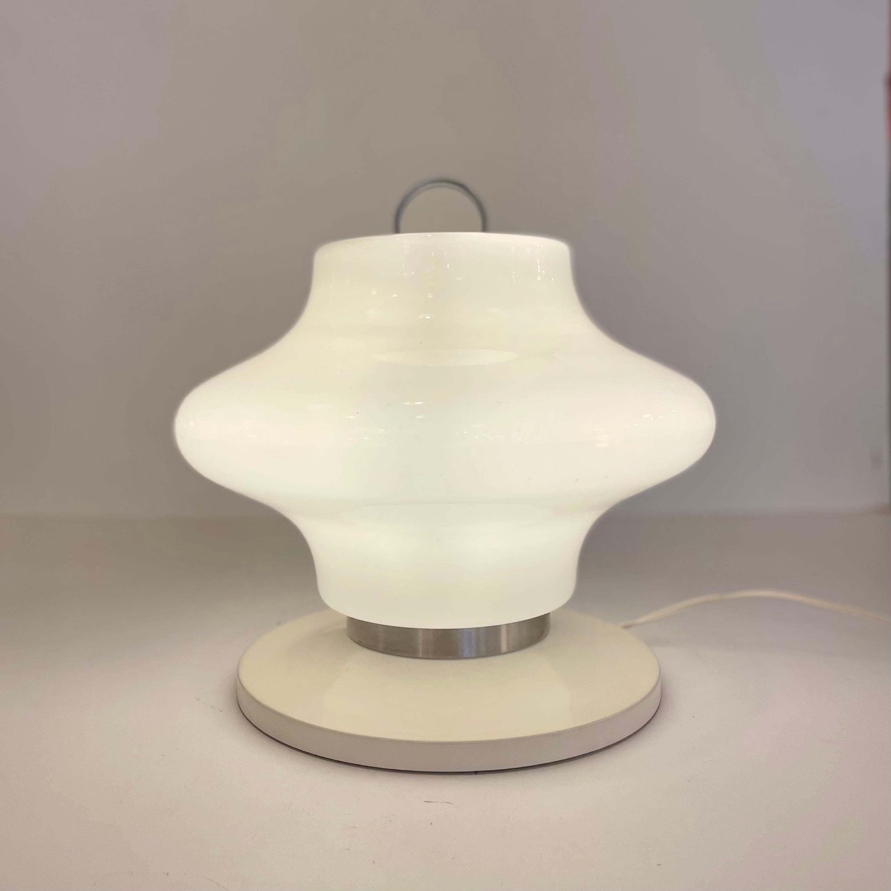 Italian portable table / floor lamp made of Murano opaline glass with a stainless steel strapping and handle on a beige enameled base, in the style go Artemide, from the 1960’s.
-
Baladeuse italienne en verre opalin de Murano avec cerclage et