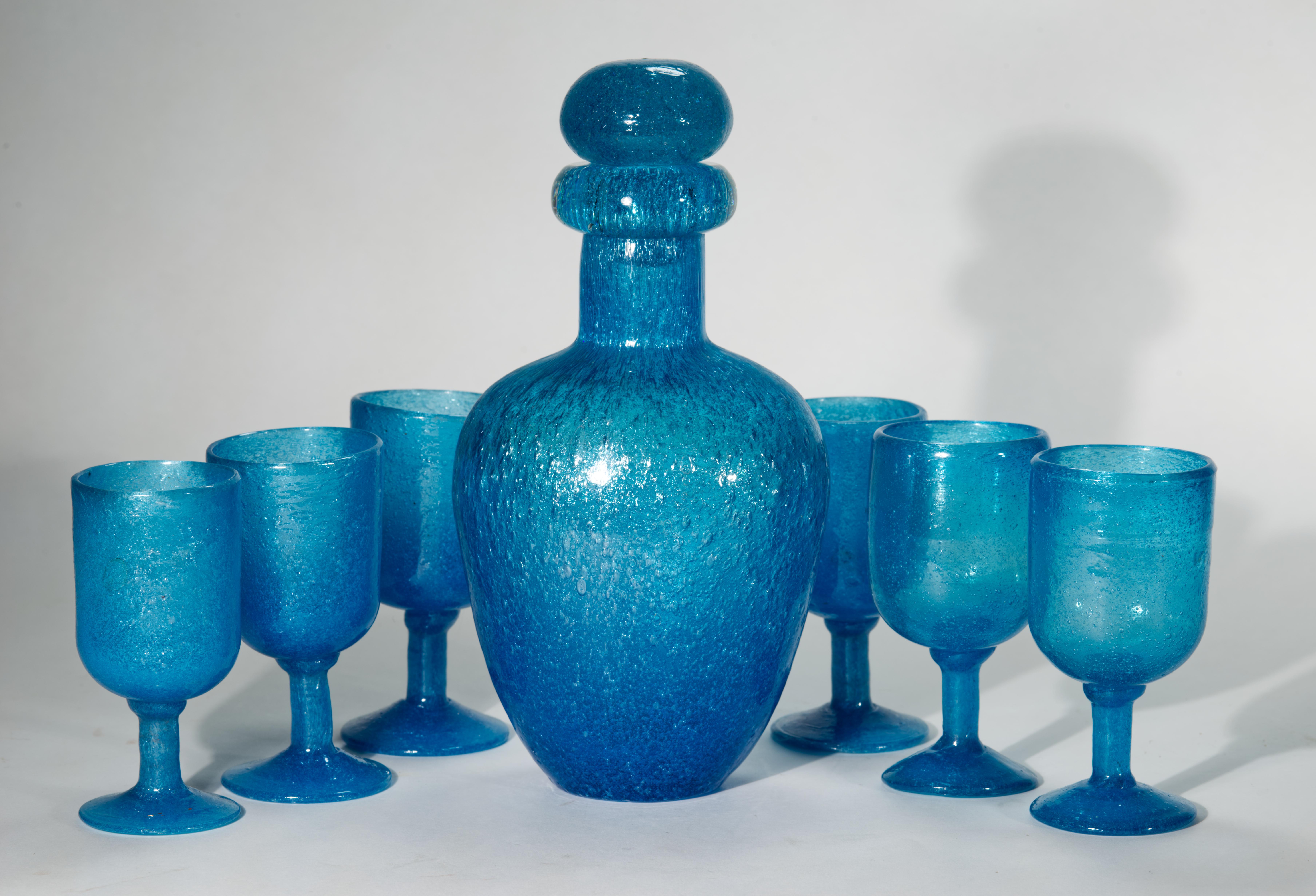  Vintage set of handblown decanter carafe with stopper and 6 footed glasses are made of blue opaque pulegoso art glass. The glass is made up of thousands of tiny air bubbles that give it a frothy effect, known as the pulegoso technique. Minimal