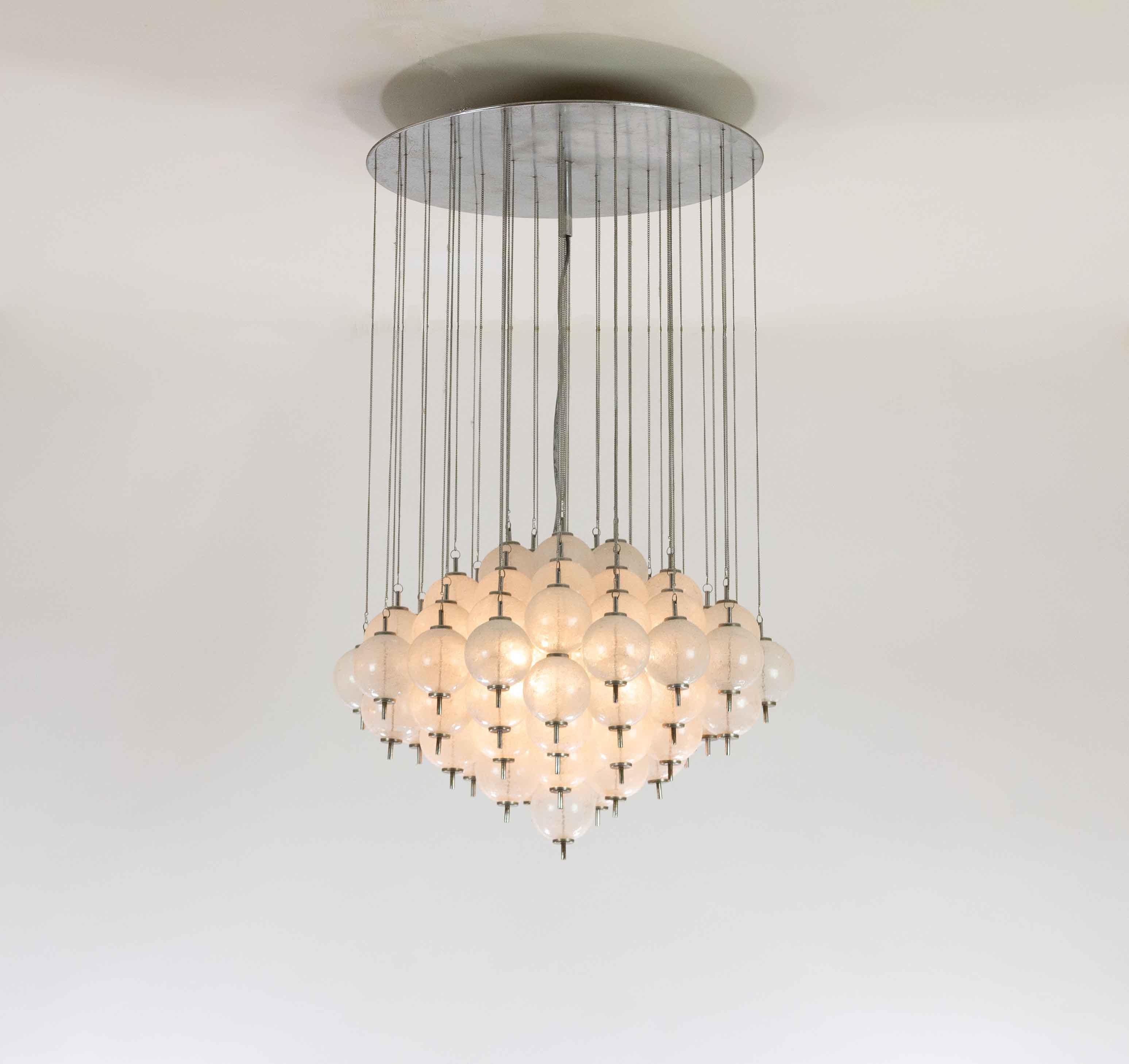 Impressive chandelier with 76 Murano glass elements from the 1960s.

The ingenious structure consists of cascading pieces of hand-blown Murano glass hanging from subtle metal chains that are connected to a round metal ceiling plate.

The spheres