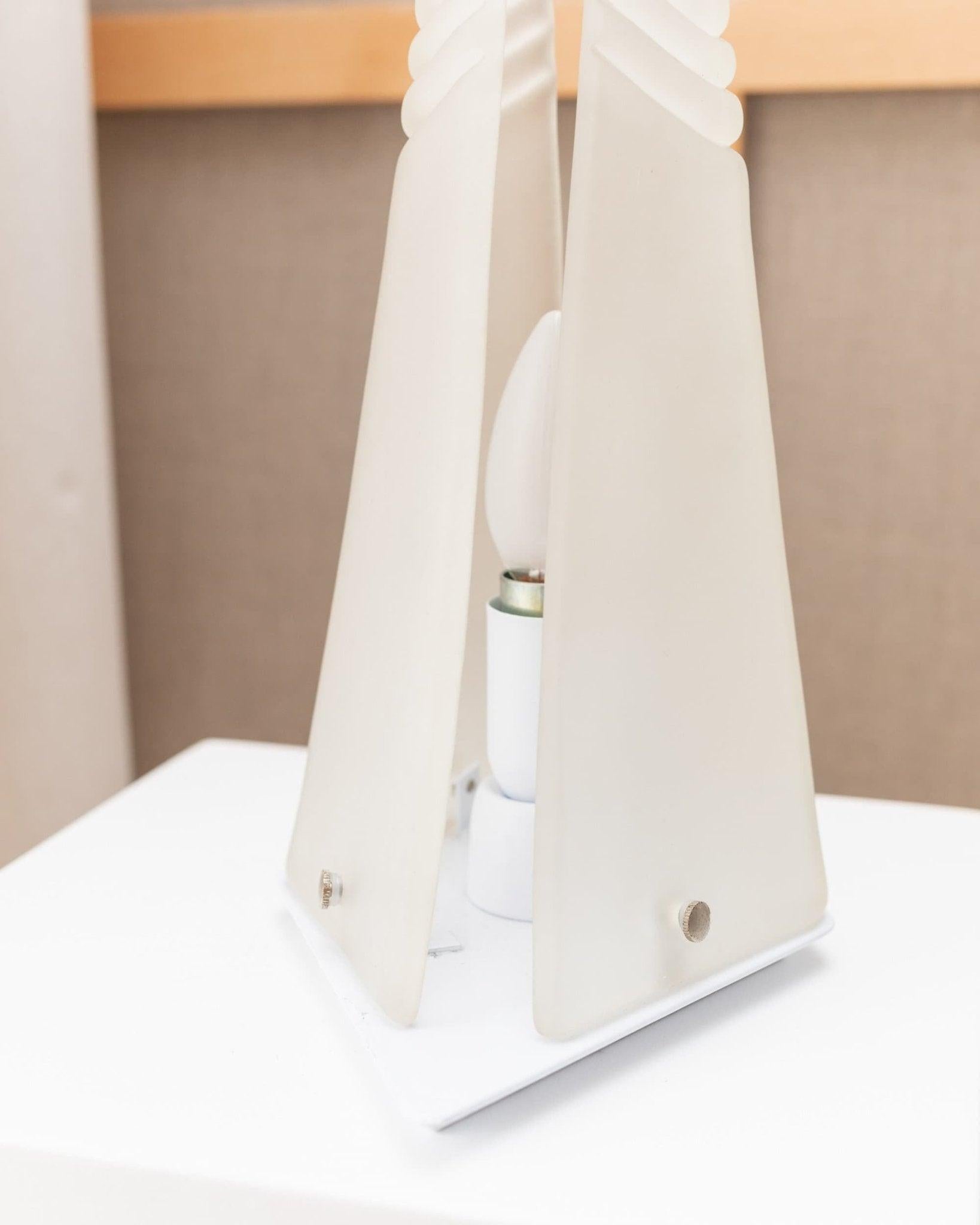 Murano pyramid table lamp in frosted glass original Space Age Design Italy,70s

This extraordinary Murano glass table lamp in pyramid shape was designed in the 1970s and made in Italy/Murano. It is made of 2 slices of milky murano glass that are