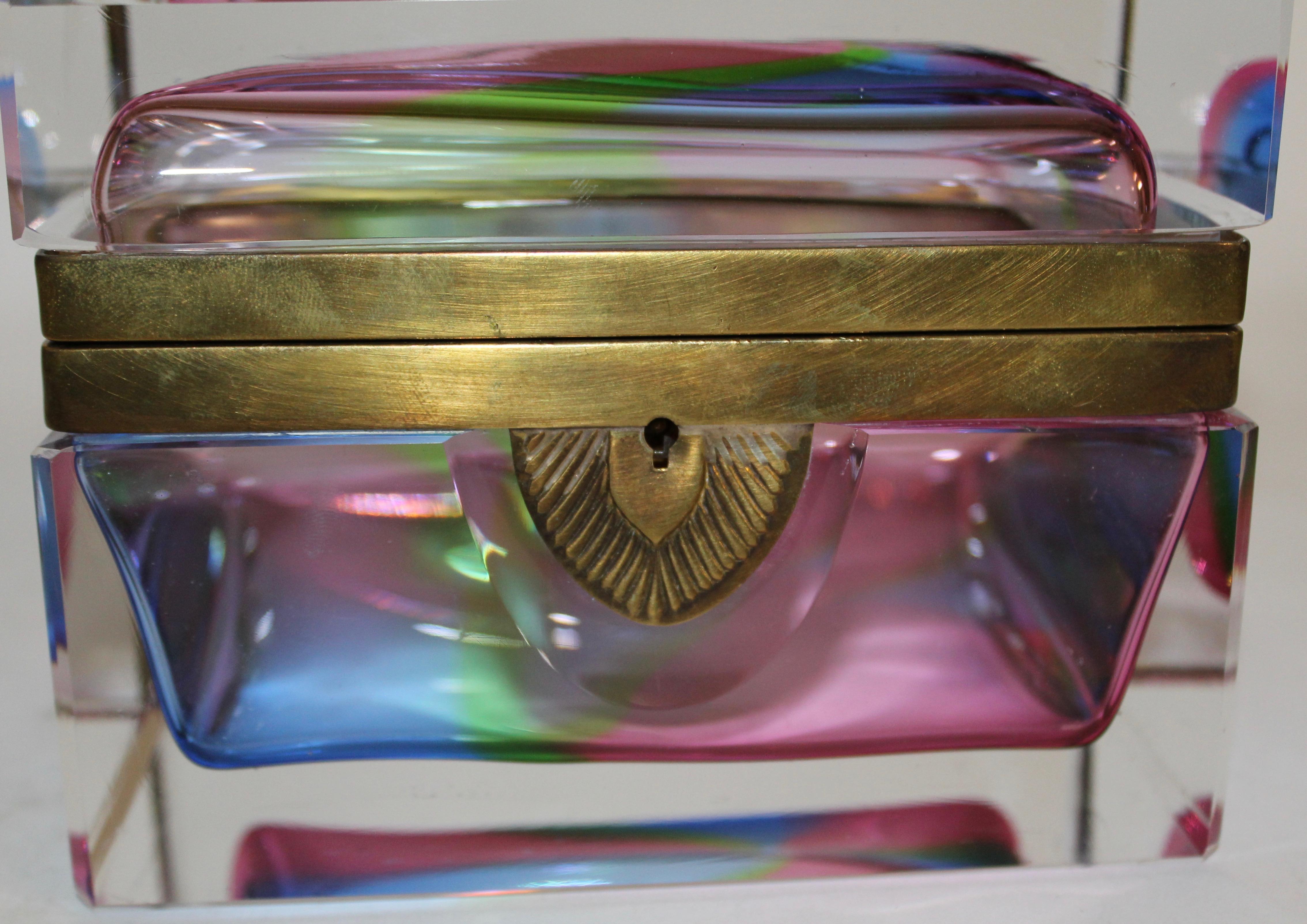 An Italian 1960s Murano glass polychromatic glass box. The thick glass with an eye-catching display of colors ranging from pinks, blues and greens creating a rainbow effect, encased in a layer of clear glass. Finished with a gilt mount and keyhole,