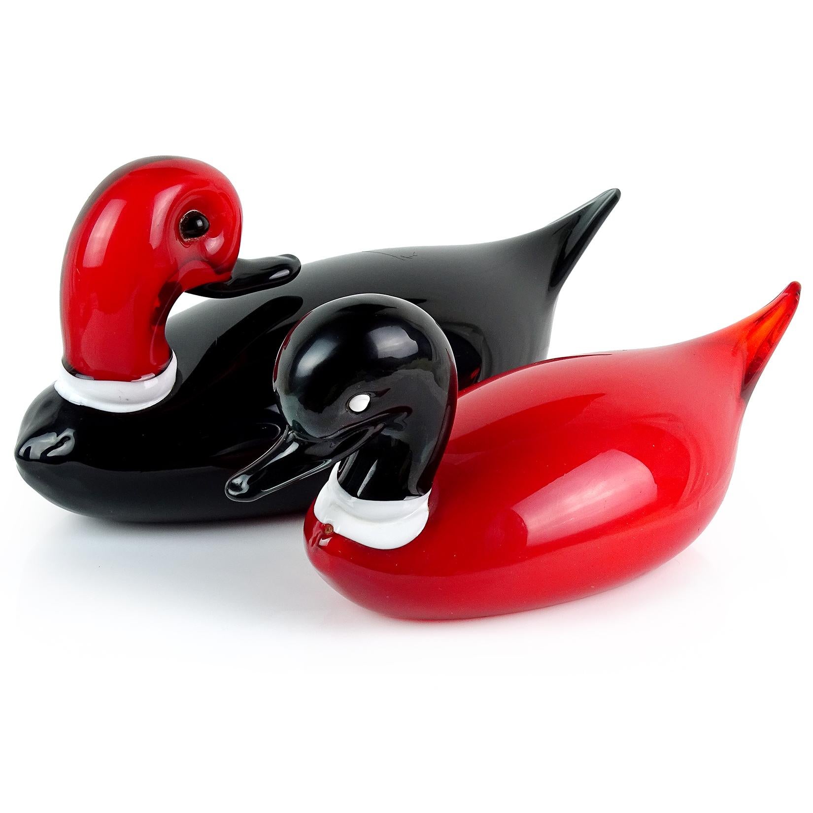 Beautiful, large, and elegant vintage Murano hand blown red and black Italian art glass duck birds sculptures. The male and female pair have white collars on the necks. One looks back and another forward. They have alternating color patterns to each