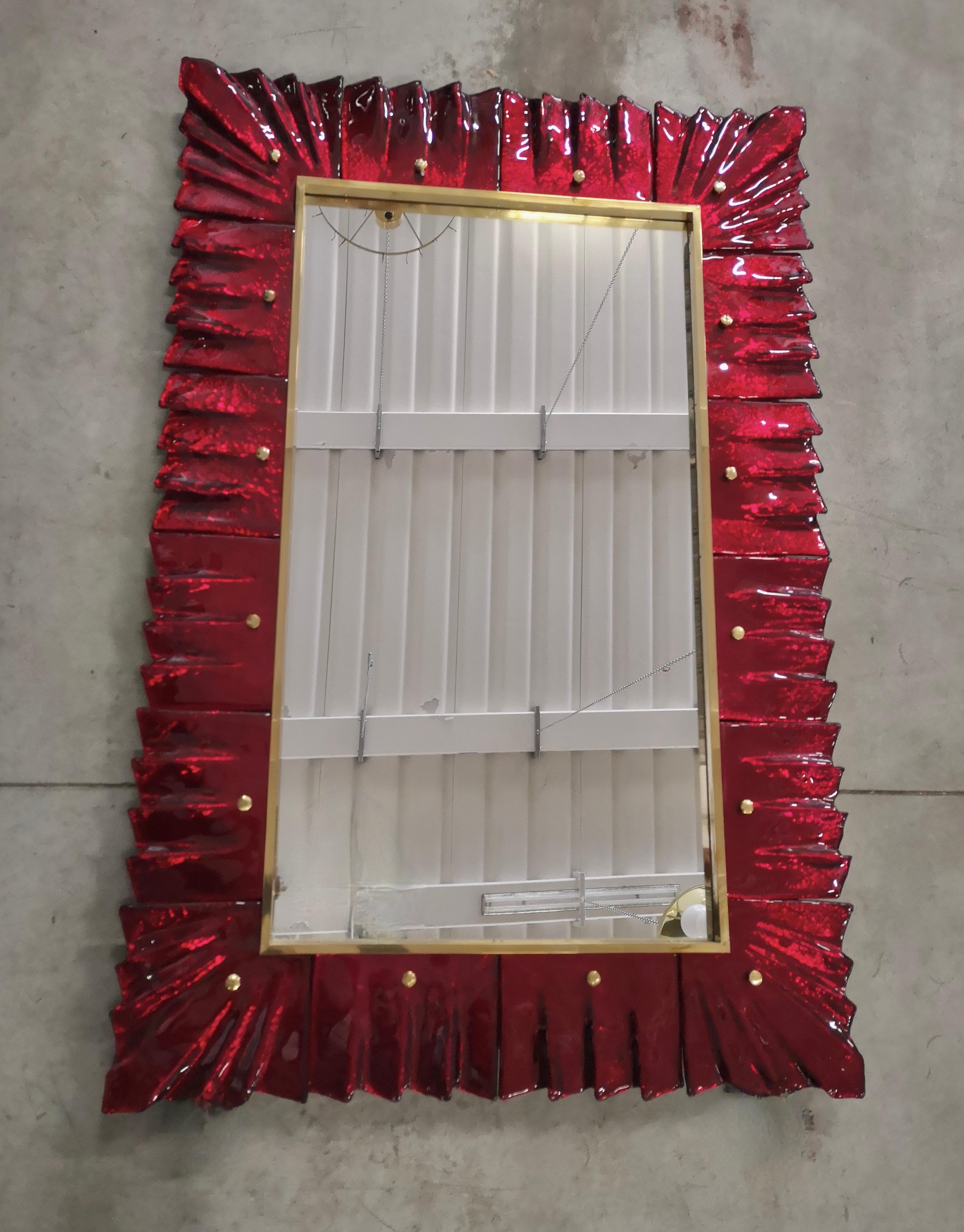A strong red color frame, reach the eye of the beholder, leaving him entranced; of Murano red art glass wall mirror. Beautifully shaped and of excellent size, the wall mirror is a real design object.

The structure of the wall mirror is in wood,