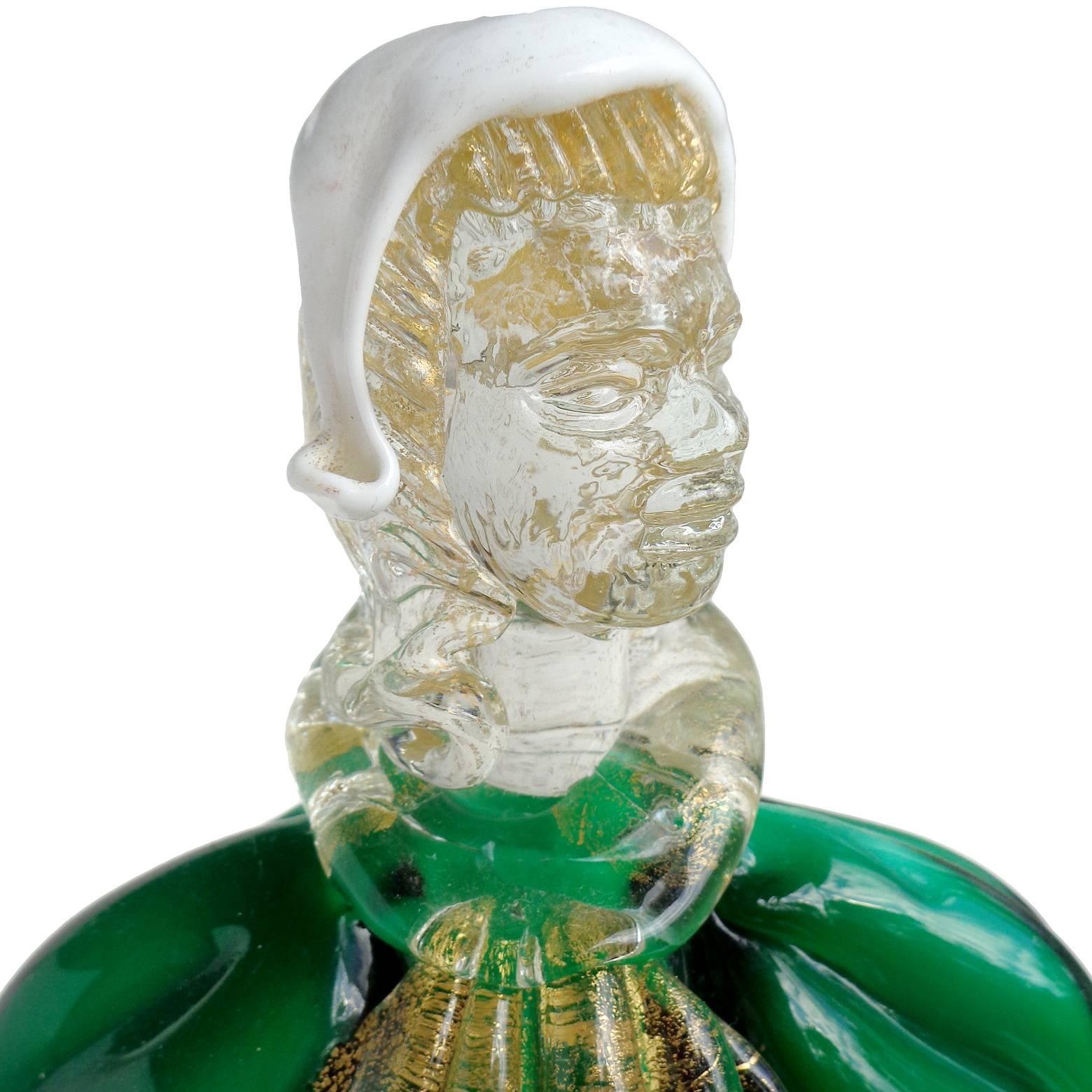 Beautiful vintage Murano hand blown green, red, white and gold flecks Italian art glass woman figure. The piece looks to be in traditional Dutch or German dress (please correct me if I am wrong). It stands on a swirling gold leaf base and has other