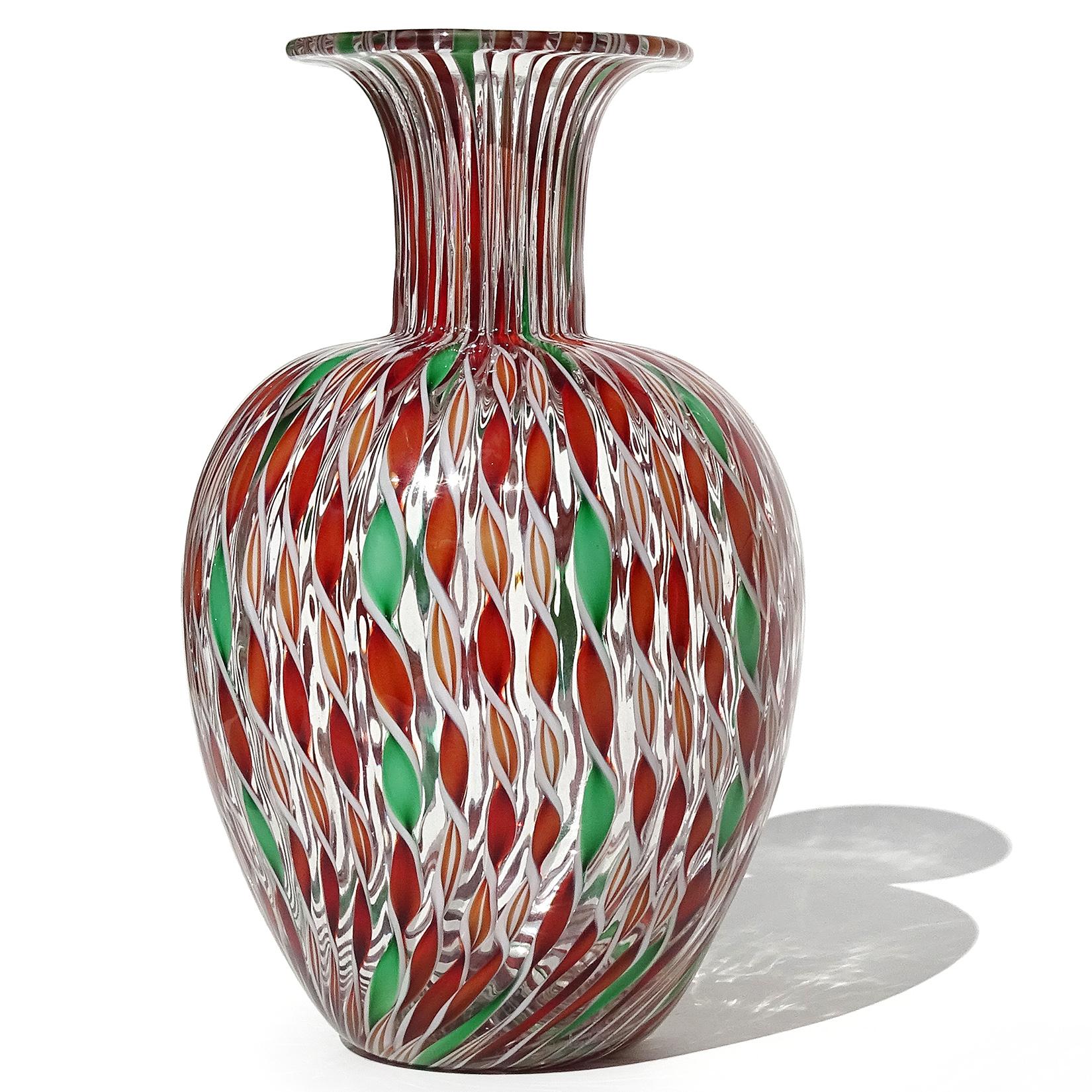 Beautiful vintage Murano hand blown red, green, orange and white twisted ribbons Italian art glass flower vase. Created in the manner of the Fratelli Toso company. The vase has an alternating repeating pattern, with the red and green ribbons between