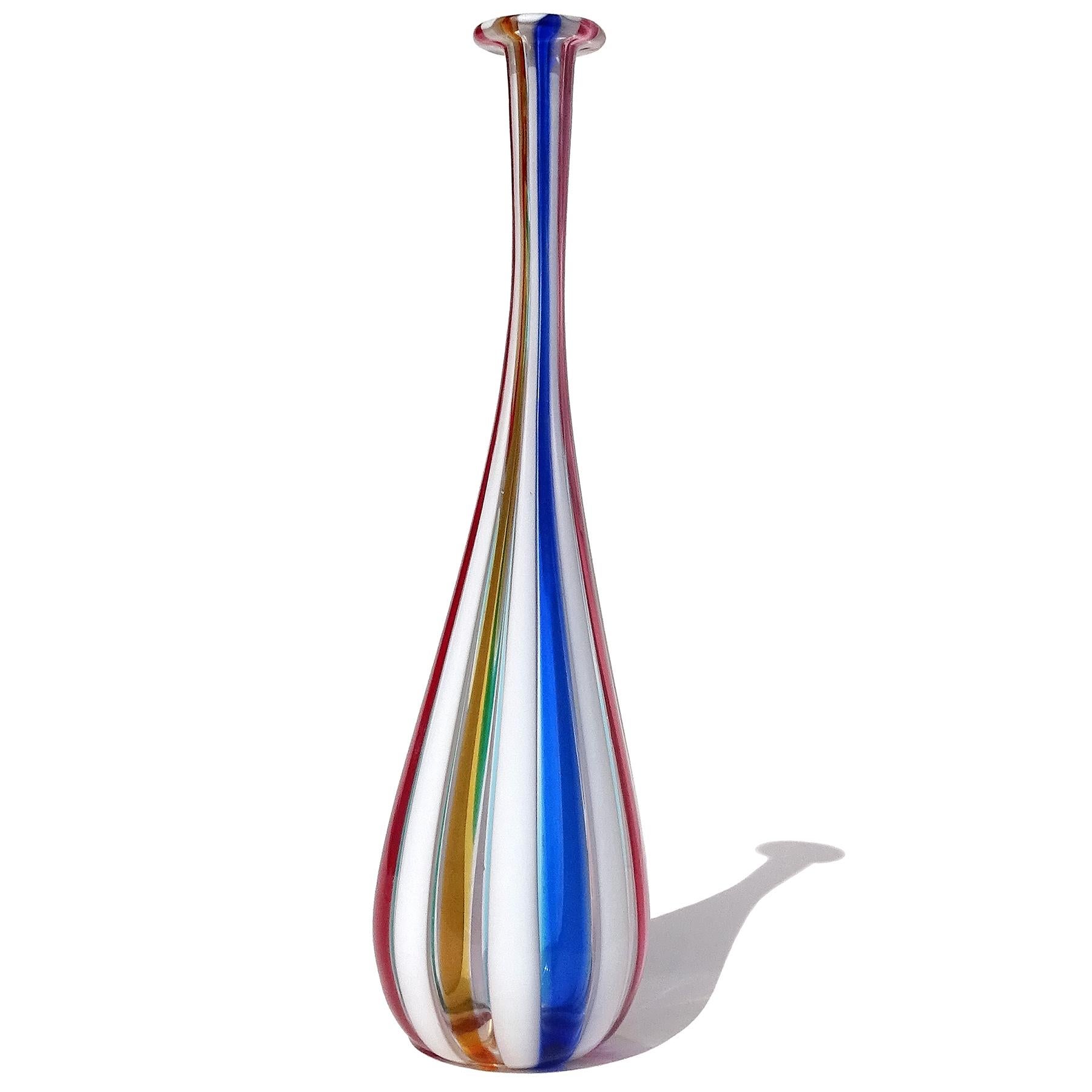 Beautiful vintage Murano hand blown multi-color vertical stripes Italian art glass soliflore / specimen flower vase. The vase has a rainbow of colors, with cobalt blue, sky blue, bright red, pink, amethyst, bright yellow orange, and emerald green.