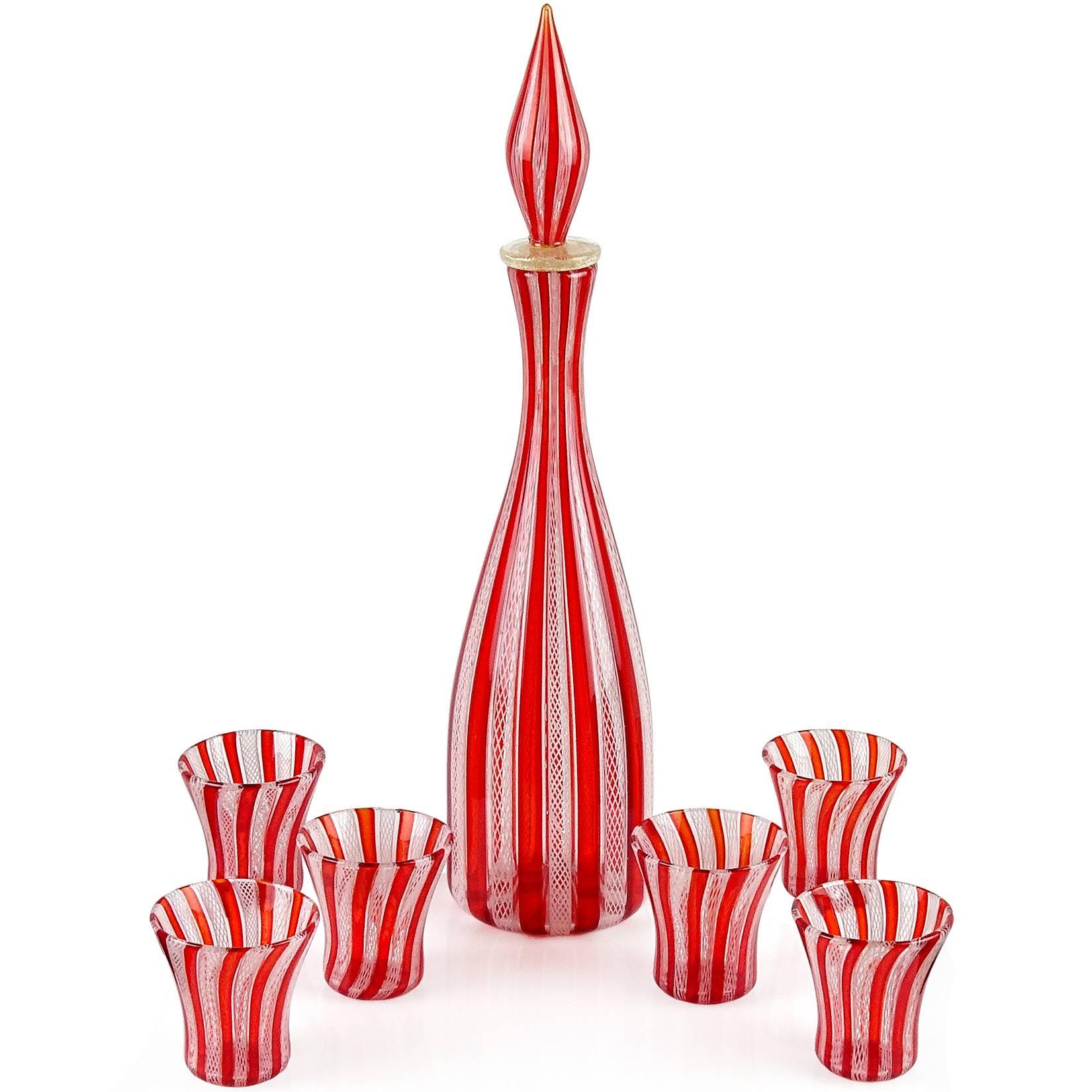 Gorgeous seven-piece Murano hand blown red “A Canne” and white Zanfirico striped ribbons Italian art glass liquor decanter and shot glasses. Created in the manner of the Salviati and Fratelli Toso companies. The decanter has an original stopper,