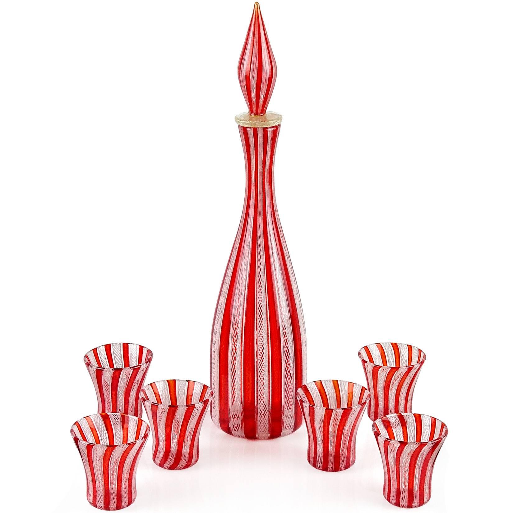 Gorgeous seven-piece Murano hand blown red “A Canne” and white Zanfirico striped ribbons Italian art glass liquor decanter and shot glasses. Created in the manner of the Salviati and Fratelli Toso companies. The decanter has an original stopper,