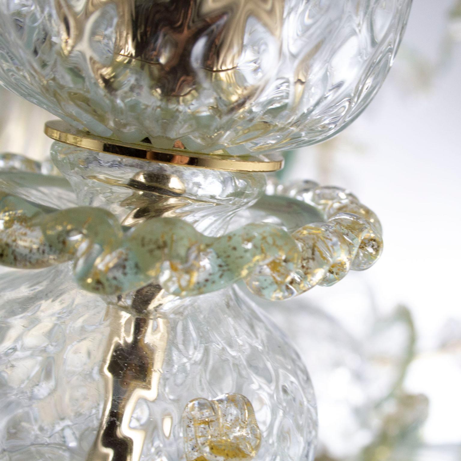 Rezzonico chandelier 10 arms, crystal Murano glass, with gold, grey-green color particulars in vitreous paste by Multiforme.
This artistic glass chandelier is an elegant and delicate lighting work, colored with pastel tones. The structure is a