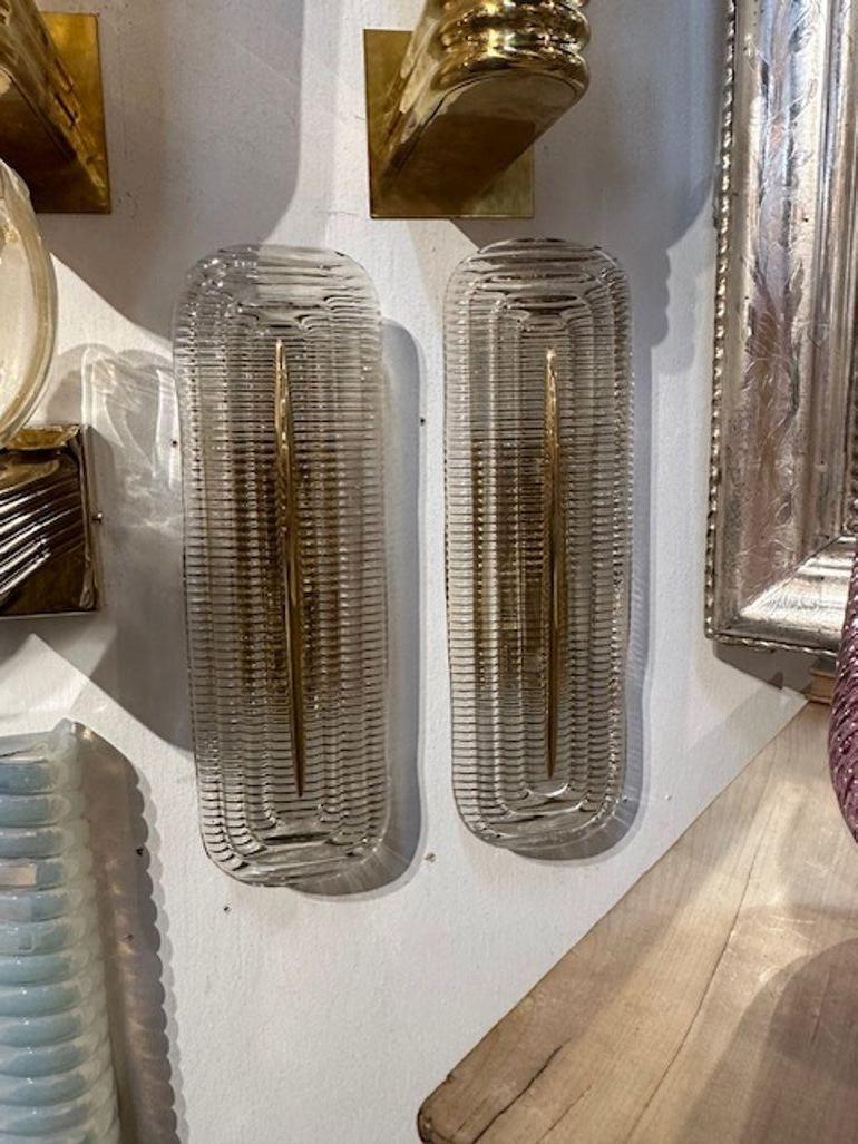 Pair of modern Murano glass and brass ribbed wall sconces. Perfect for today's design! The sconces have been professionally rewired and ready to hang.
