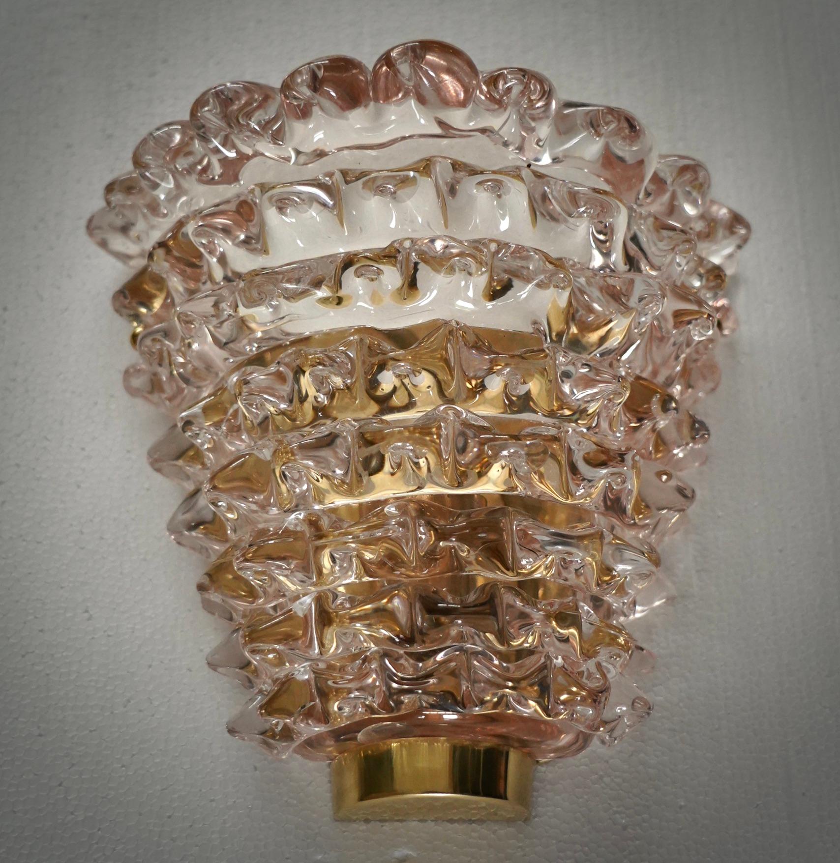 Diseño refinado y delicado para este aplique de cristal de Murano rosa transparente.

El aplique está formado por una estructura de latón que permite alojar una hermosa semicopa de cristal de Murano rosa transparente. El diseño es muy limpio y