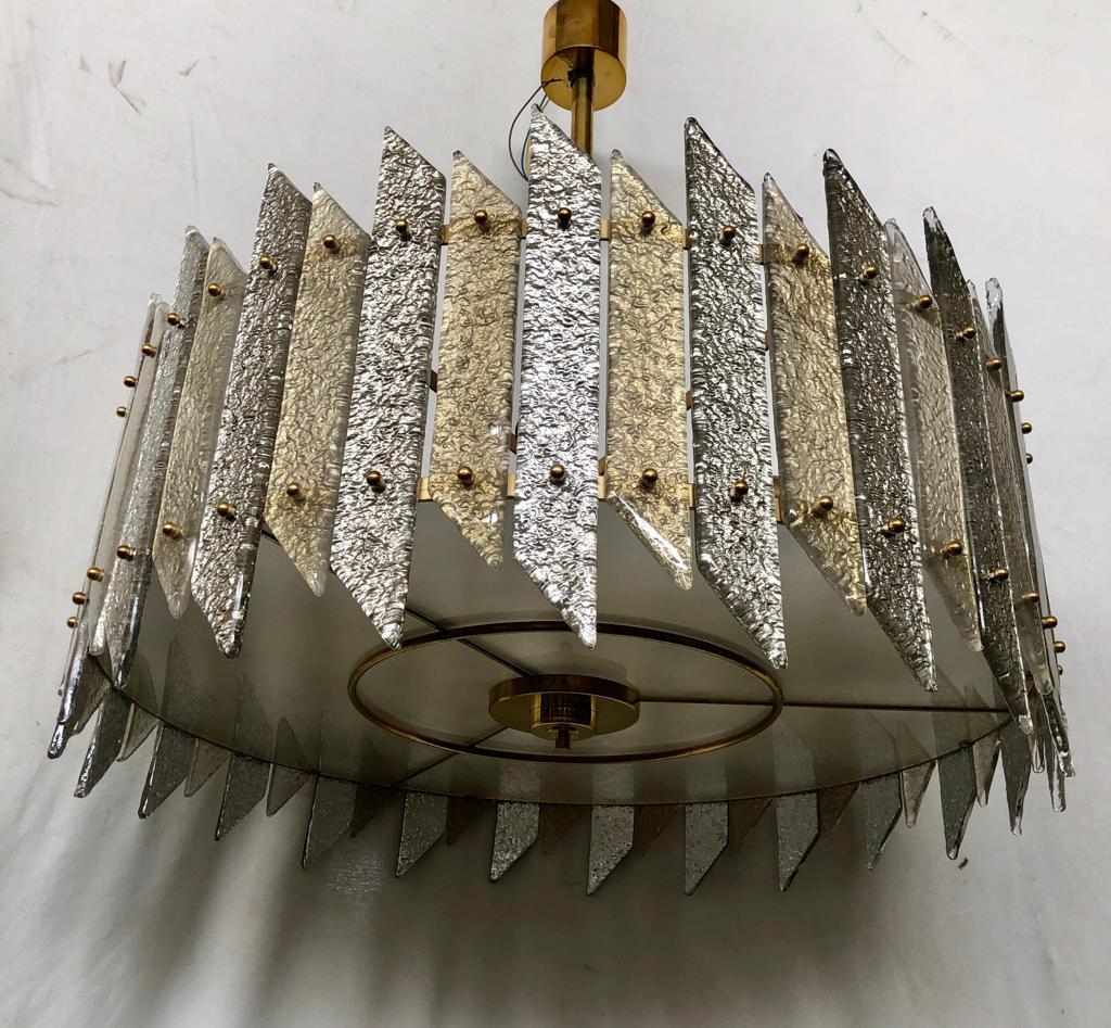 Very elegant Murano chandelier in art glass and brass. The Murano furnaces create an indisputable timeless design, simple but elegant at the same time.

Its structure is round and made of iron colored in gold, with specially cut and colored slides