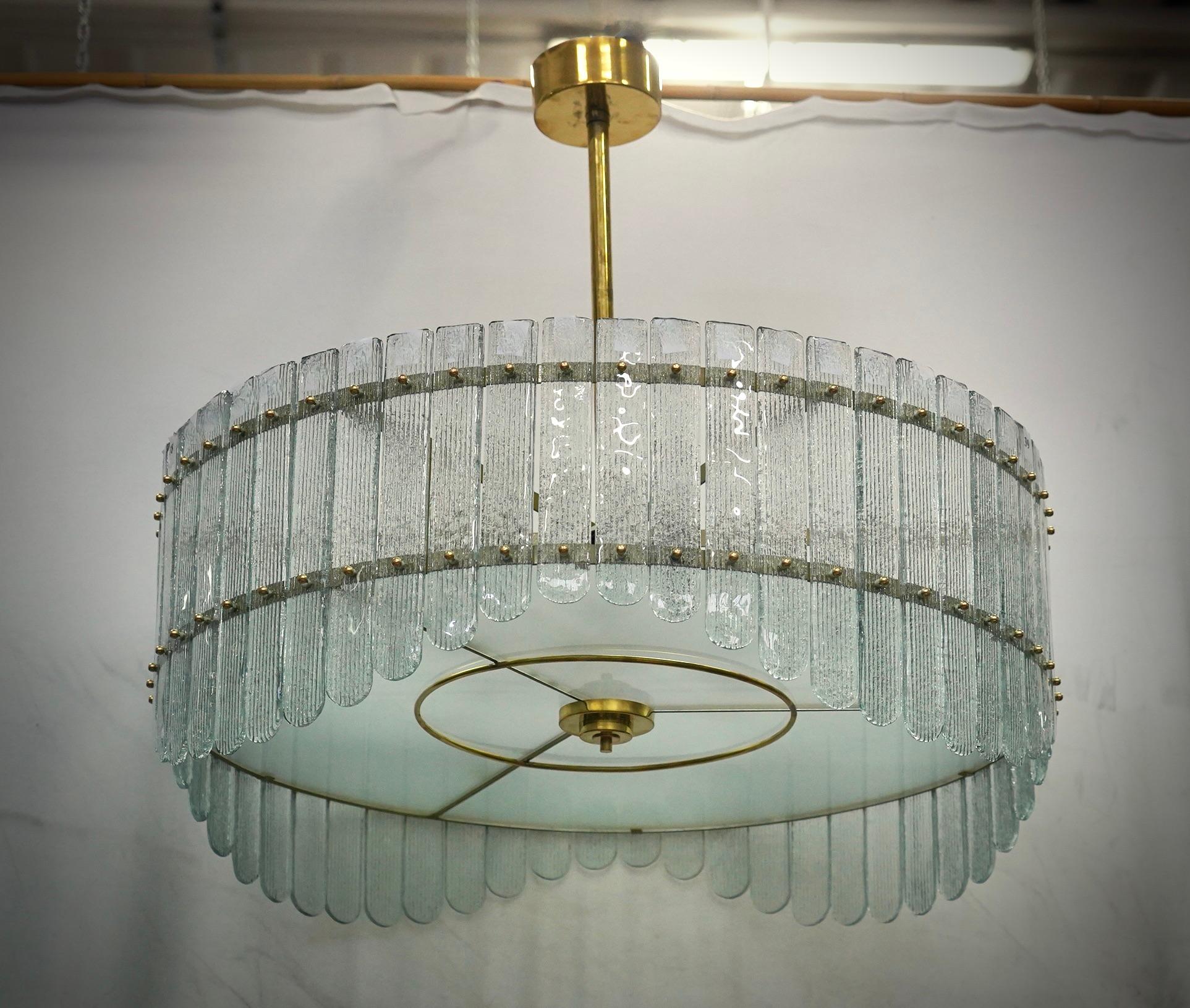 Stupendo lampadario/luce da soffitto in un sorprendente colore ghiaccio trasparente; un tondo perfetto con lastre di vetro color ghiaccio.

La sua struttura è rotonda e realizzata in ferro color oro, con piastre appositamente tagliate posizionate