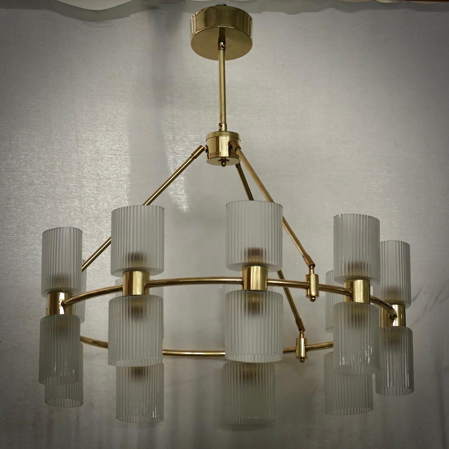 Elegante lampadario di Murano dalla caratteristica struttura circolare, dal design unico e lineare ma molto raffinato.

Il lampadario è composto da una struttura circolare in ottone lucido, su cui sono state posizionate delle coppe in vetro di
