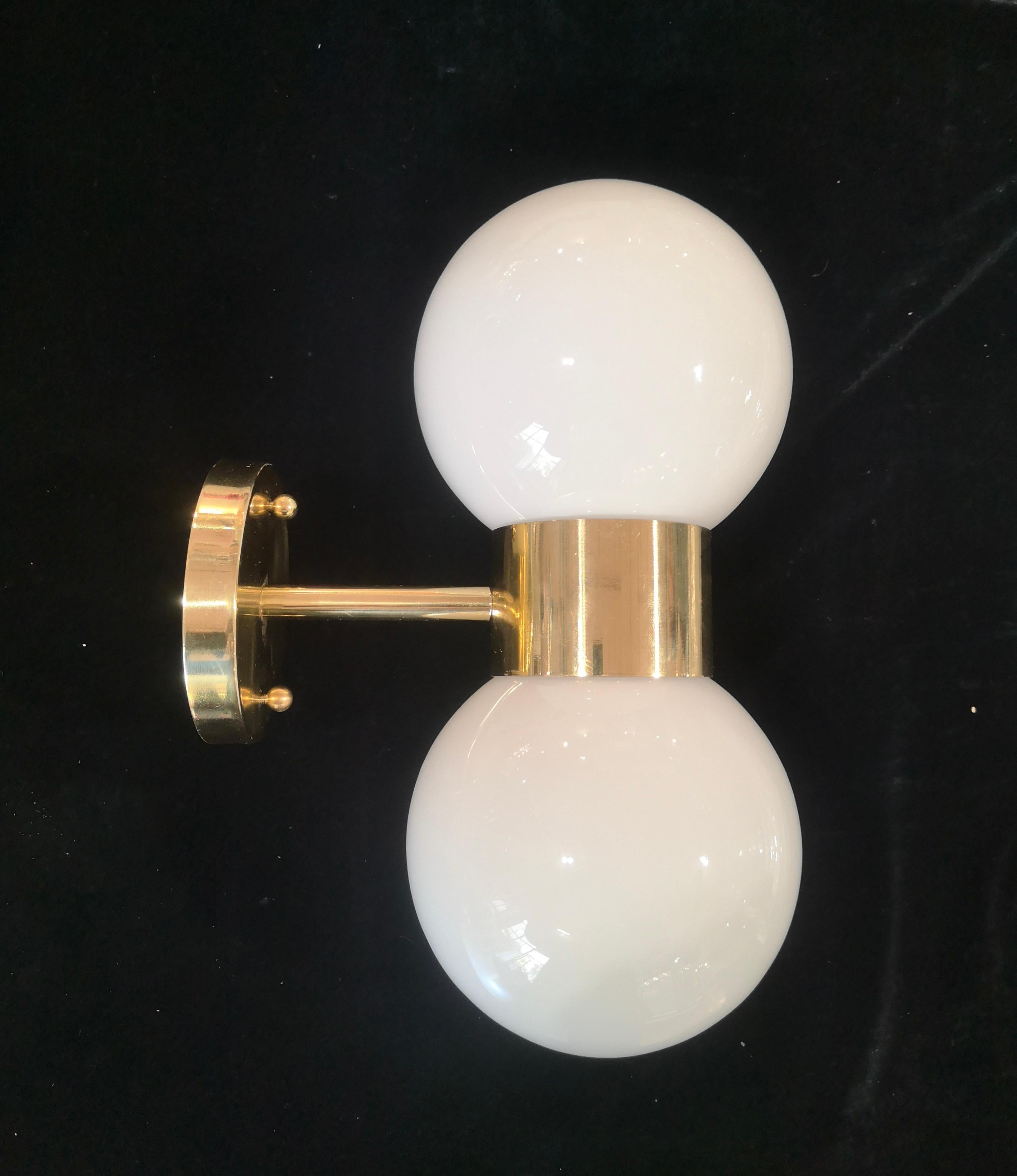 Refined and delicate design for this wall light with white Murano glass.

The applique is formed by a brass structure that allows the superimposed housing of two beautiful white Murano glass spheres. The design is very clean and simple, but at the
