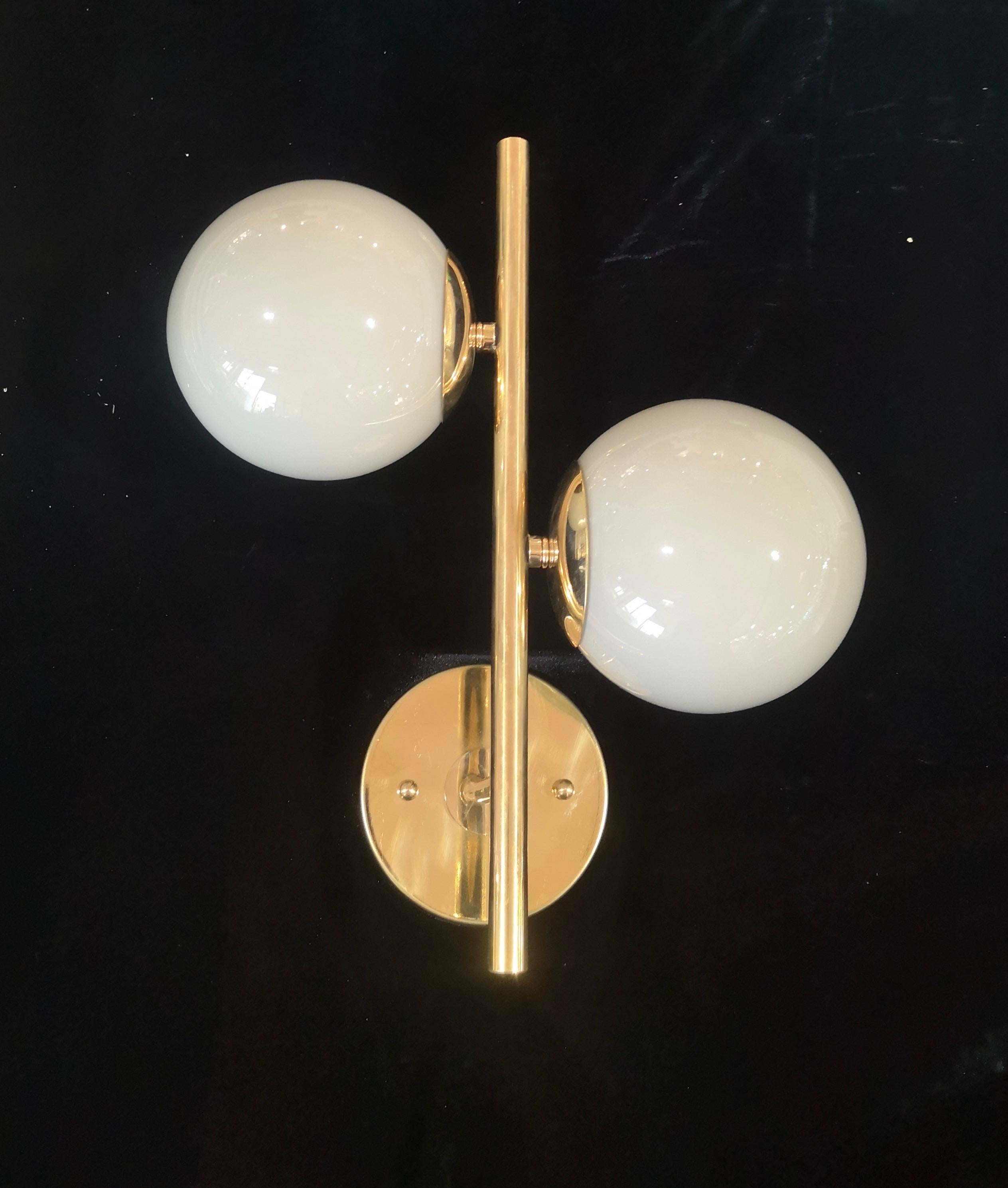 Refined and delicate design for this wall light with white color Murano glass.

The applique are made up of a brass structure that allows the housing of a beautiful white color Murano glass sphere. The design is very clean and simple, but at the