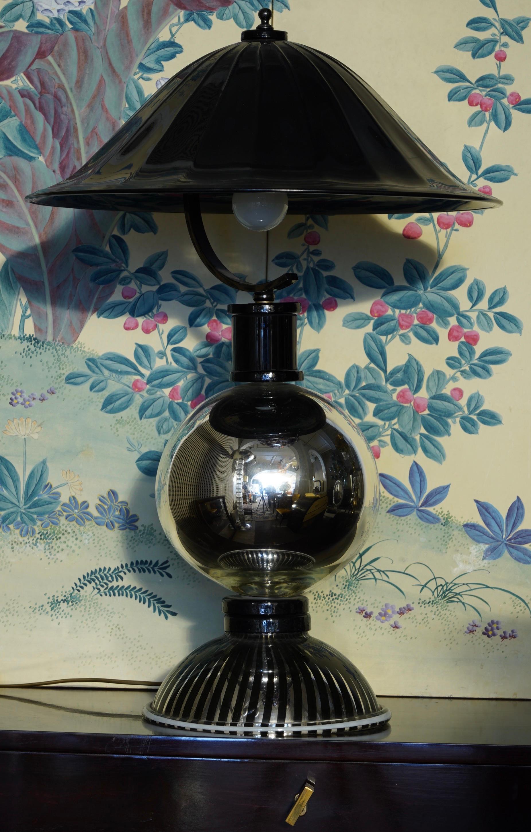 Extravagant Murano table lamp, characterized by a large ribbed black glass hat.

The lamps have a central body made up of spheres and half-spheres in mirrored glass, with a large black glass hat on top held by a black metal structure. Black glass