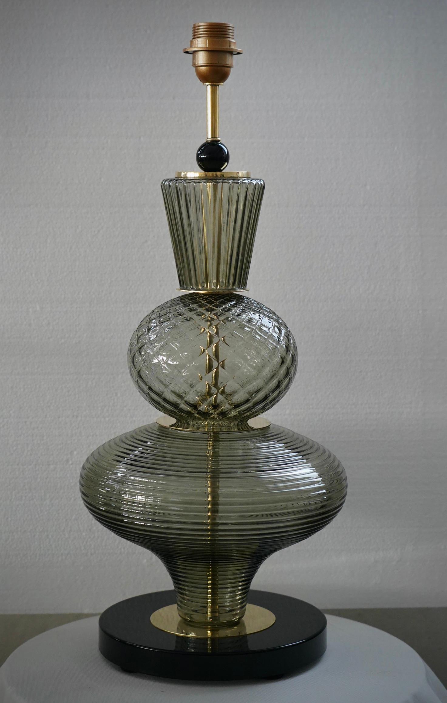 Lampe de table sculpture en verre de Murano, très particulière et originale en son genre. Sa forme est fascinante, grâce aux pièces très particulières en verre de Murano.

La lampe est composée d'une base ronde en verre noir et d'une tige sur