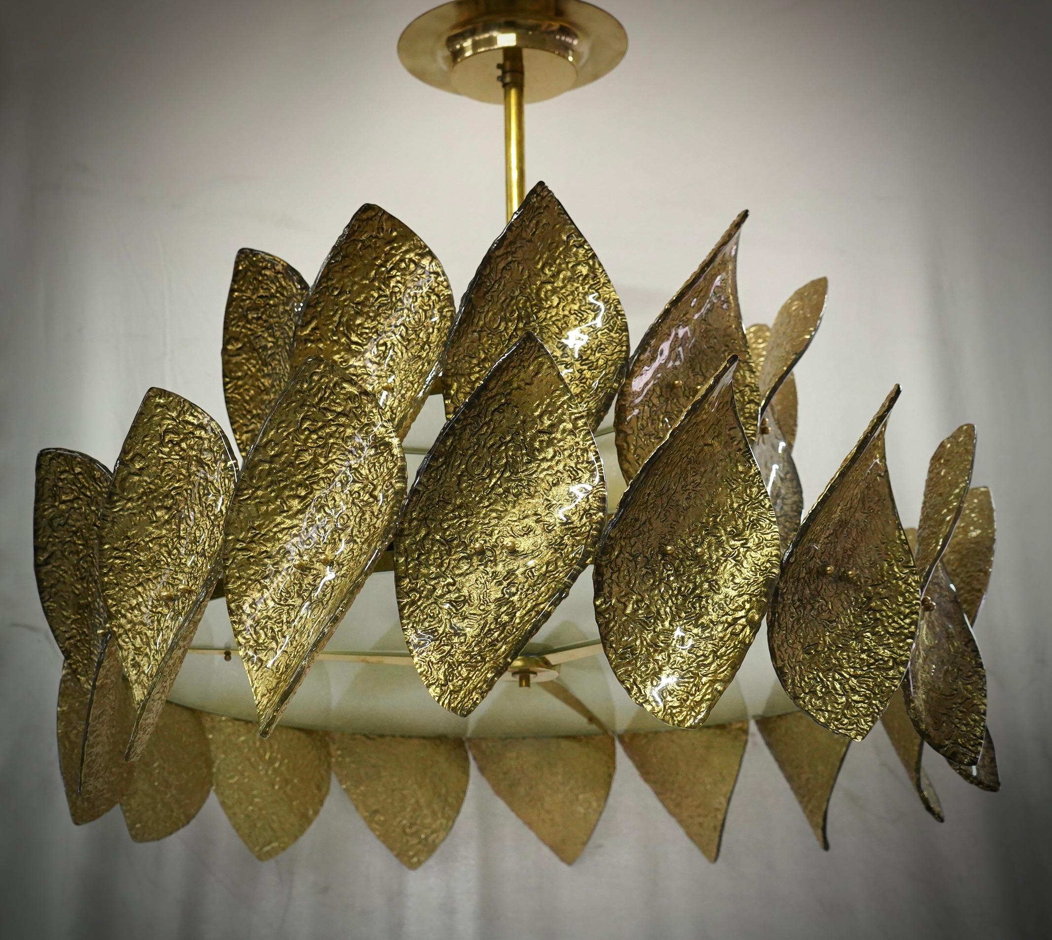 A riot of leaves, with an elegant gold colour. Very beautiful, rich and original design. Fantastic round chandelier in Murano glass and polished brass. Note the shape of the gold-colored Murano glass leaves, very fine and particular.

Brass