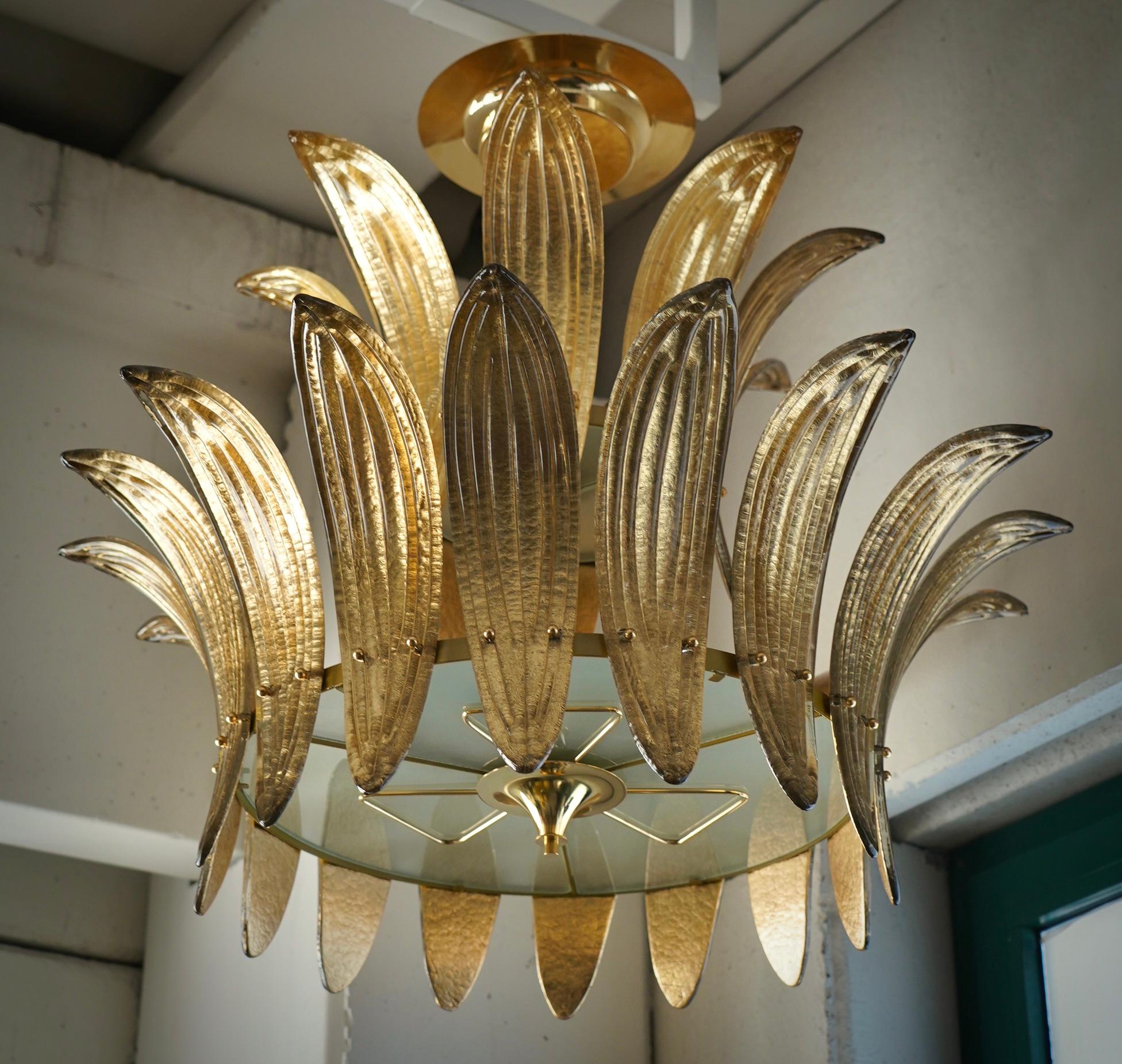 Ein Aufruhr von Blättern mit einer eleganten goldenen Farbe. Sehr schönes, reichhaltiges und originelles Design. Fantastischer runder Kronleuchter aus Murano-Glas und poliertem Messing. Beachten Sie die Form der goldfarbenen Murano-Glasblätter, sehr