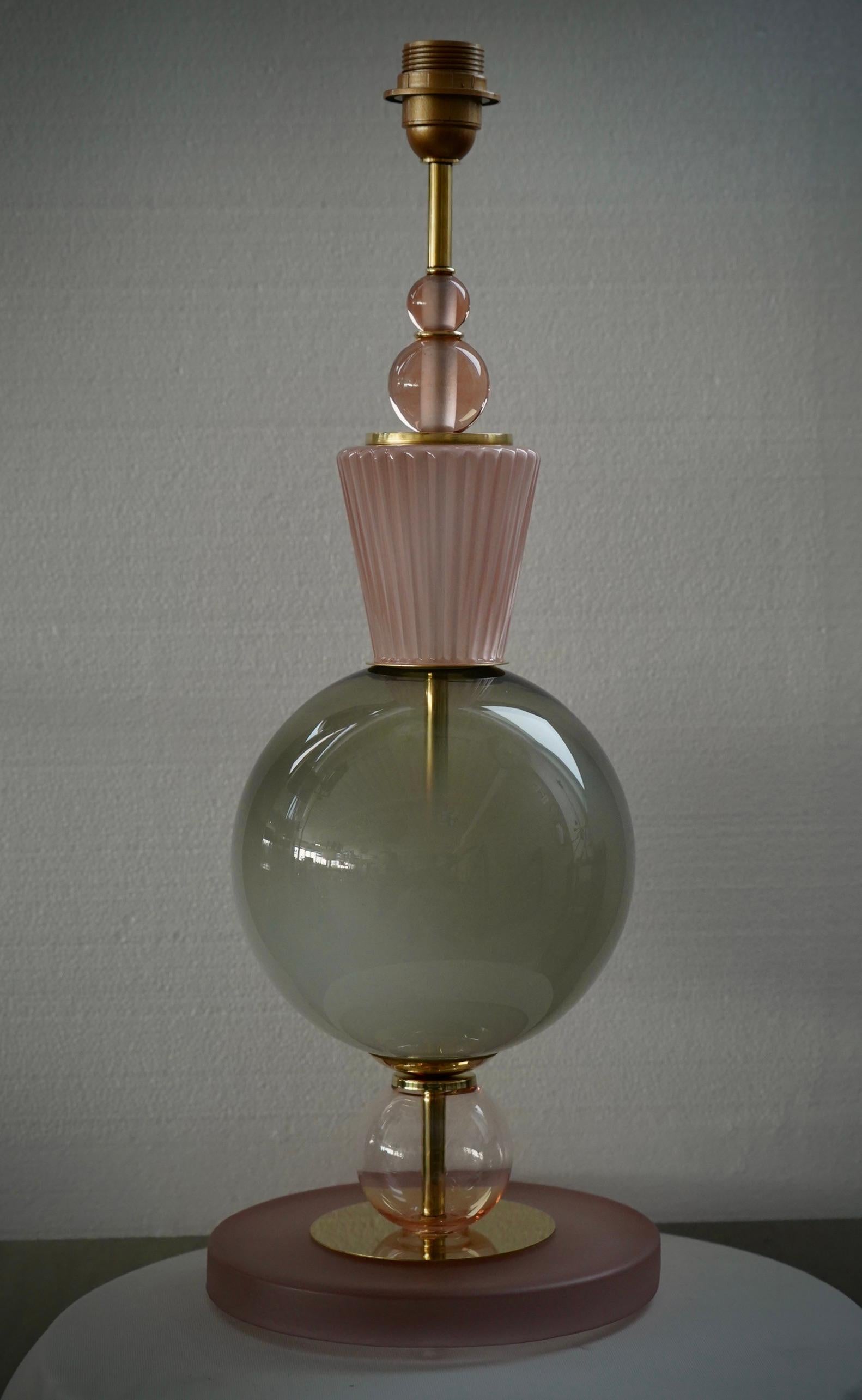 Une lampe de table sculpture en verre de Murano, très particulière et originale en son genre. Leur forme est fascinante, en raison des parties en verre de Murano très caractéristiques.

La lampe est composée d'une base ronde en verre rose opaque et