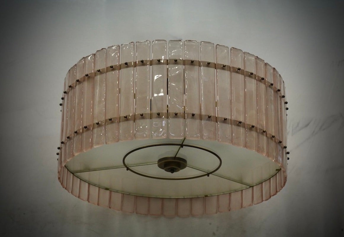 Superbe lustre/plafonnier dans une couleur rose pâle saisissante ; un tour parfait avec des plaques de verre rose.

Sa structure est ronde et faite de fer doré, avec des plaques spécialement découpées et colorées placées tout autour du périmètre,
