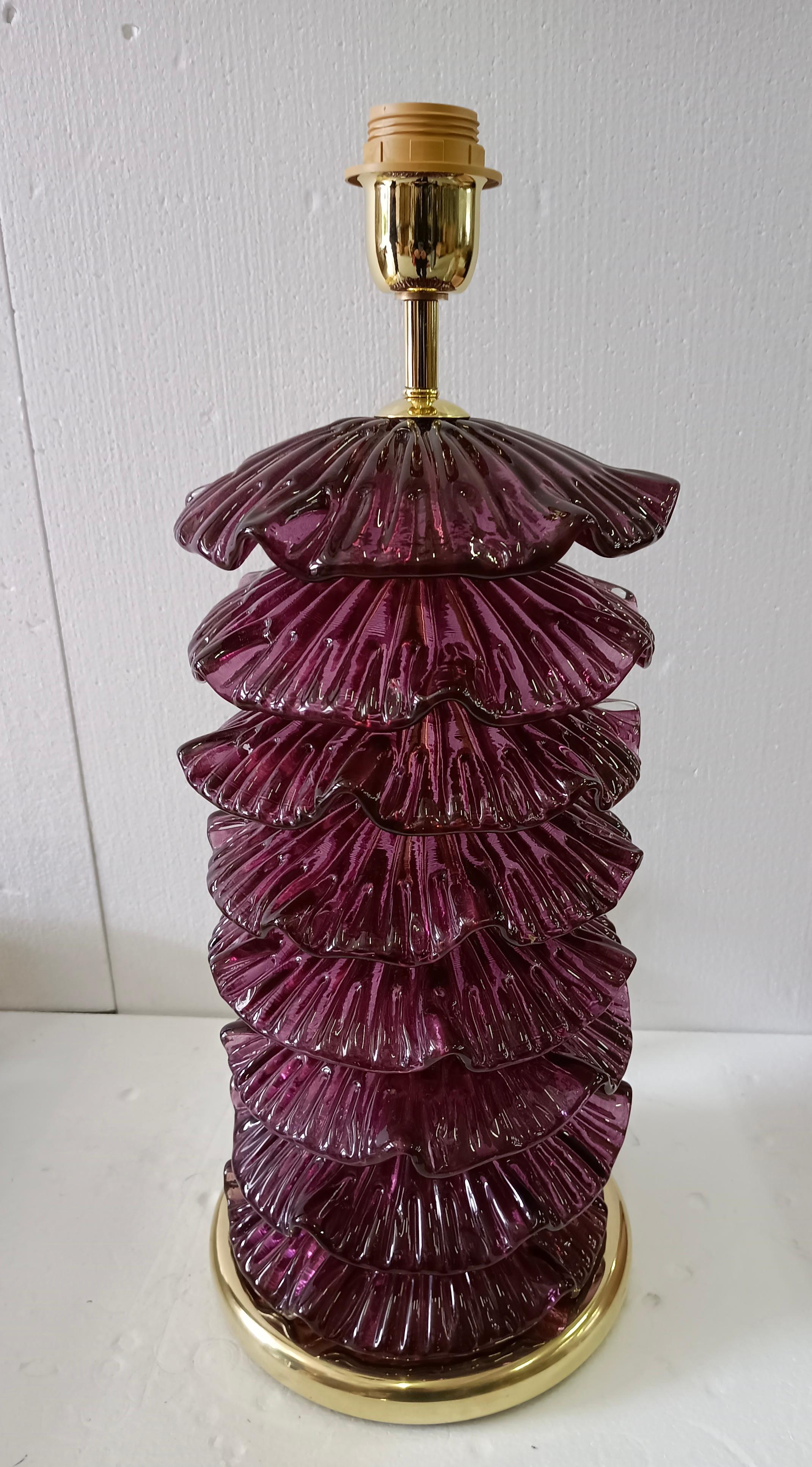 Une lampe très particulière et originale de Murano, une série de feuilles de verre rondes disposées les unes au-dessus des autres, d'une couleur violette. Leur forme est fascinante.

La lampe est composée d'une base ronde en laiton et d'une tige sur