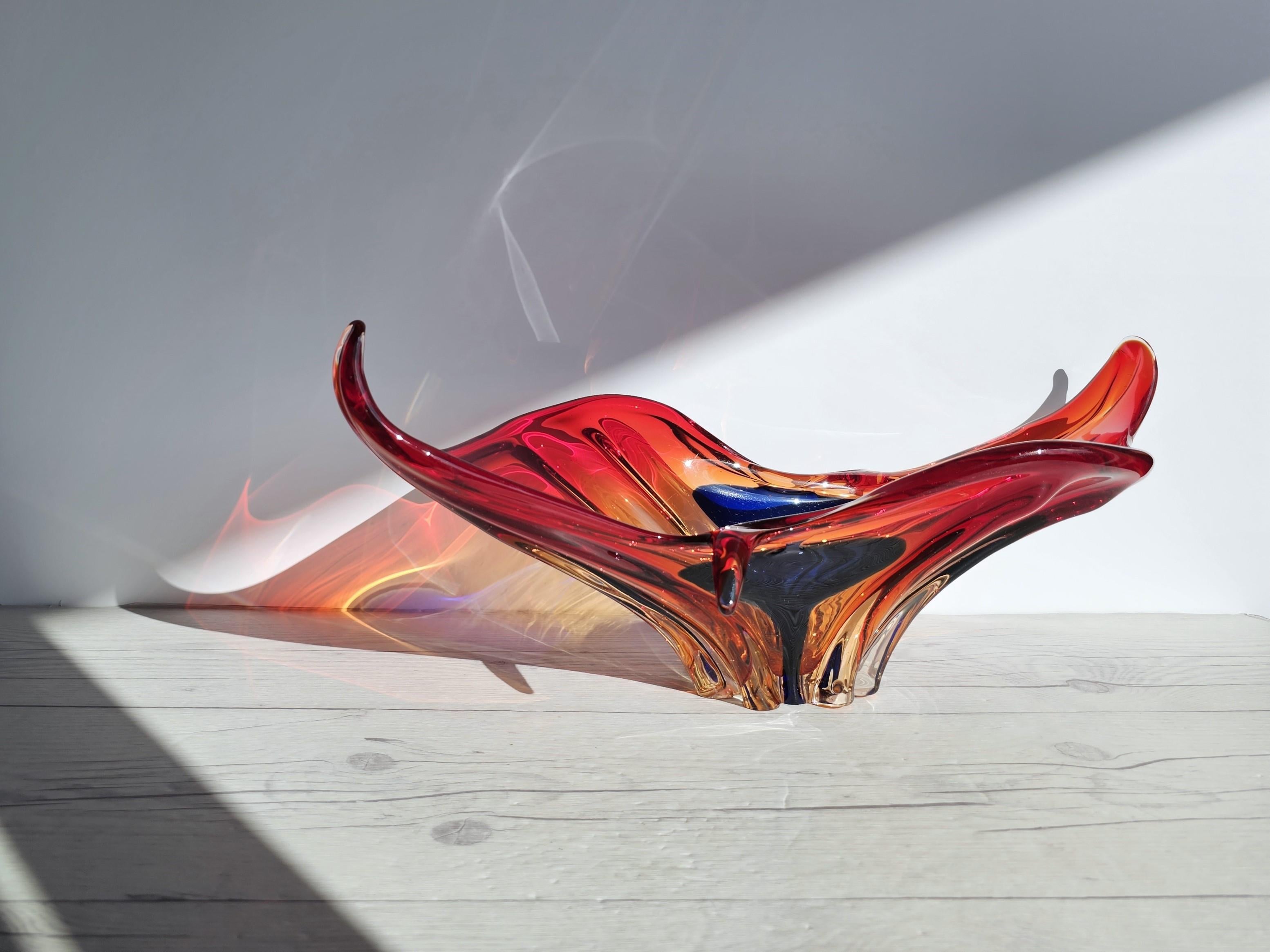 This striking and vivid work of handblown, Italian mid-century art glass design brings with it the beauty created by expert Murano art glass techniques. 

The form is that of a stylised, unfurling splash, expertly hot-worked into the elegantly