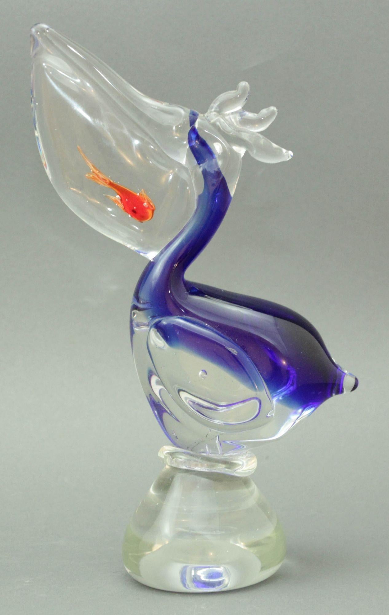 Murano Style Italy Art Glass Sculpture Hand Blown Pelican with Goldfish Italian Design 1960s.
Gracious form, rich colors that seem to flow inside the glass and create a delicate play of light in cobalt blue red and and clear glass.
Realized in the