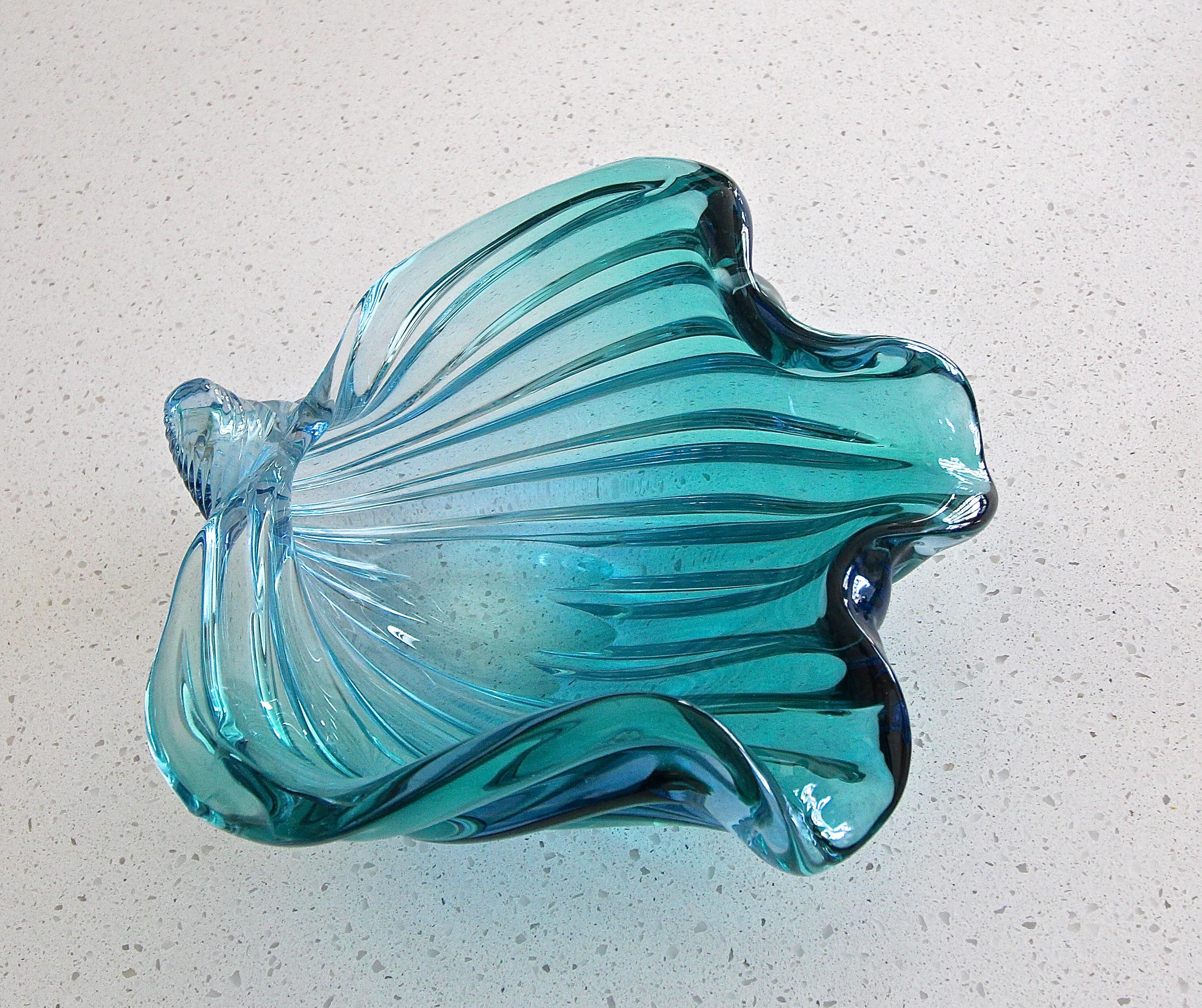 Seashell or conch shaped Murano Italian hand blown aqua blue twisted ribbed glass bowl by Seguso. The glass color is a vibrate aqua blue, and depending on light source and surrounding has subtle shades of darker blue.