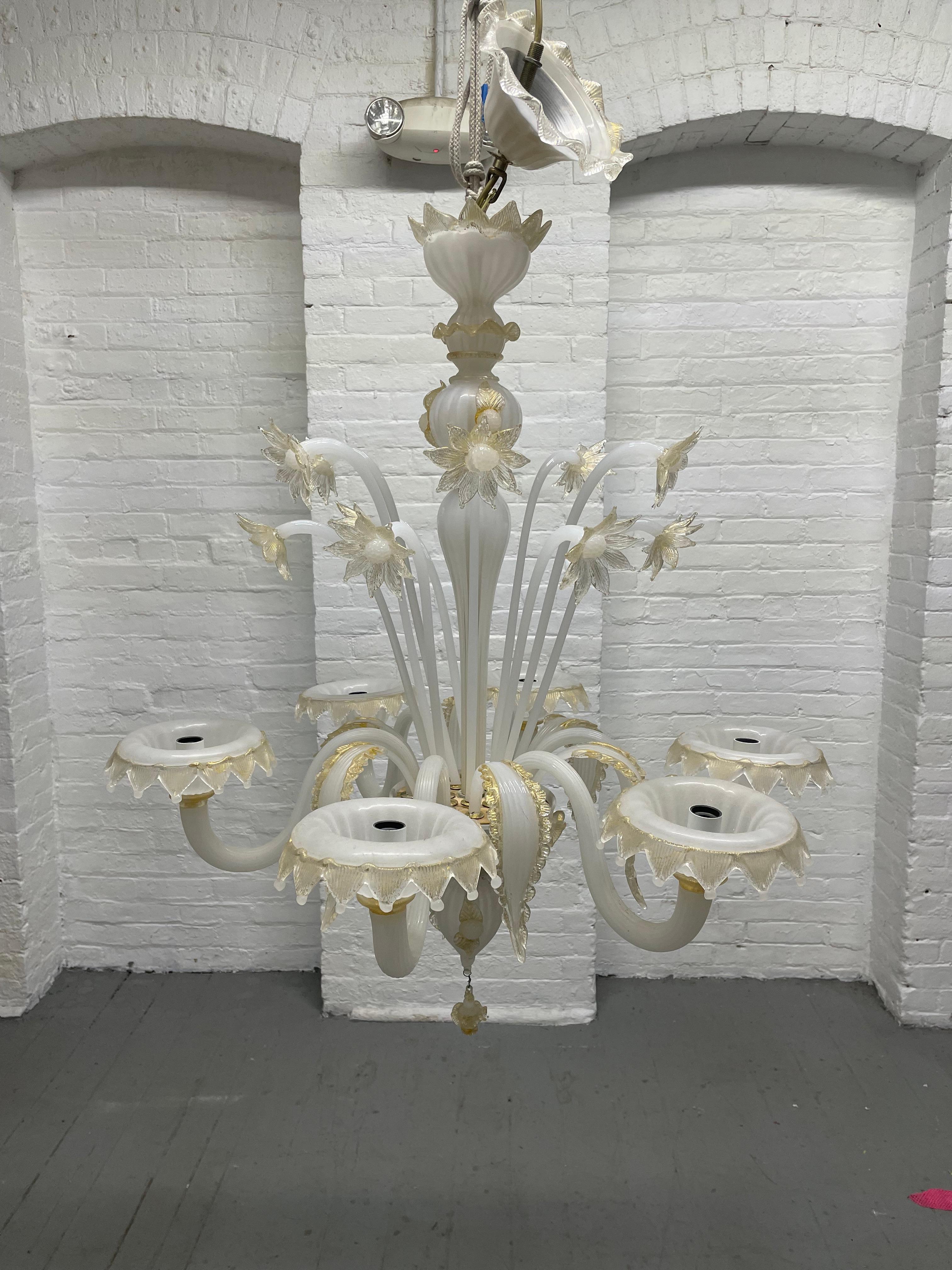 Murano glass chandelier with floral pattern. Has gold and off white petals and leaves.