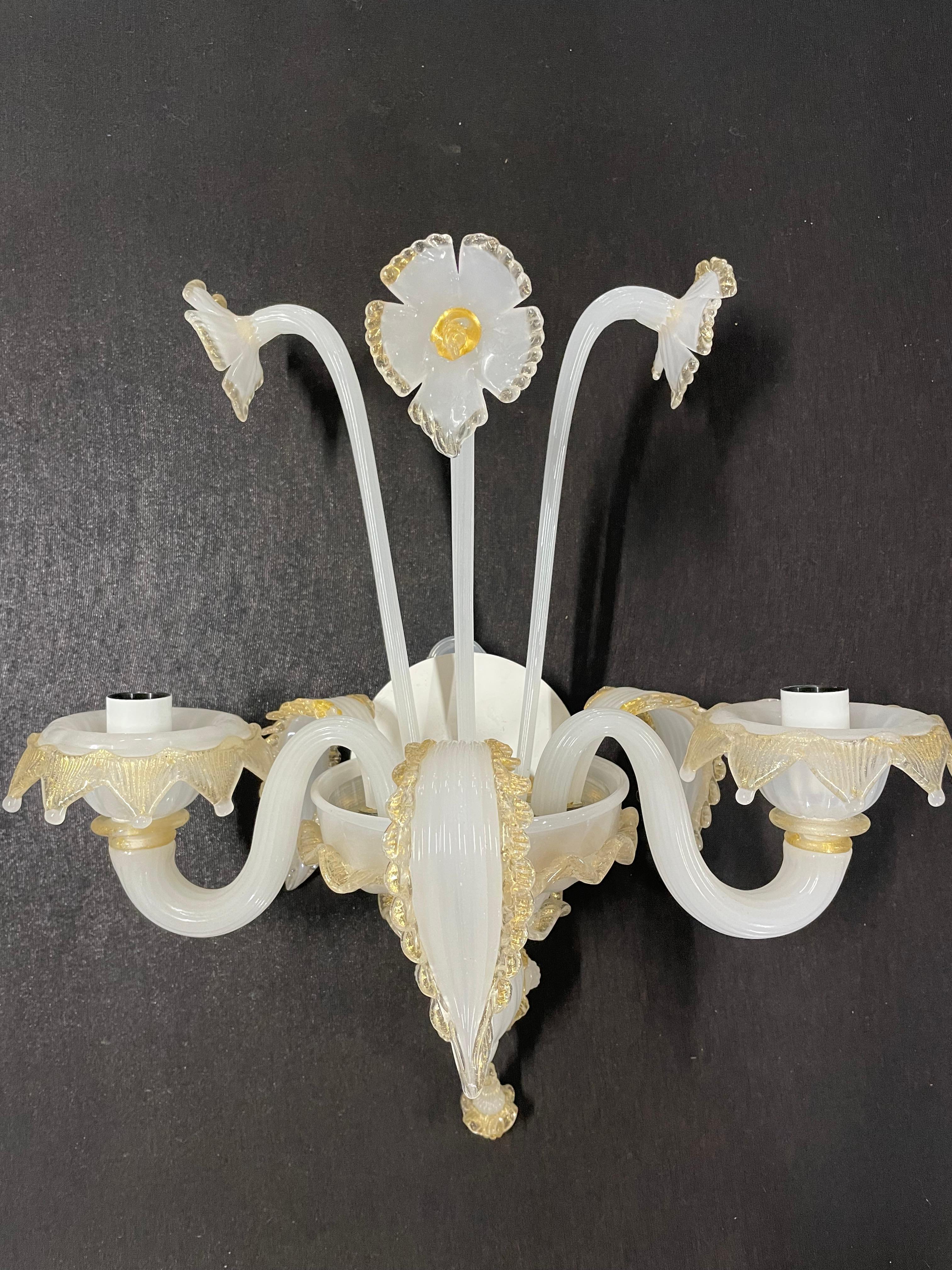 Pair of Murano glass sconces with floral pattern. Has gold and off-white petals and leaves.