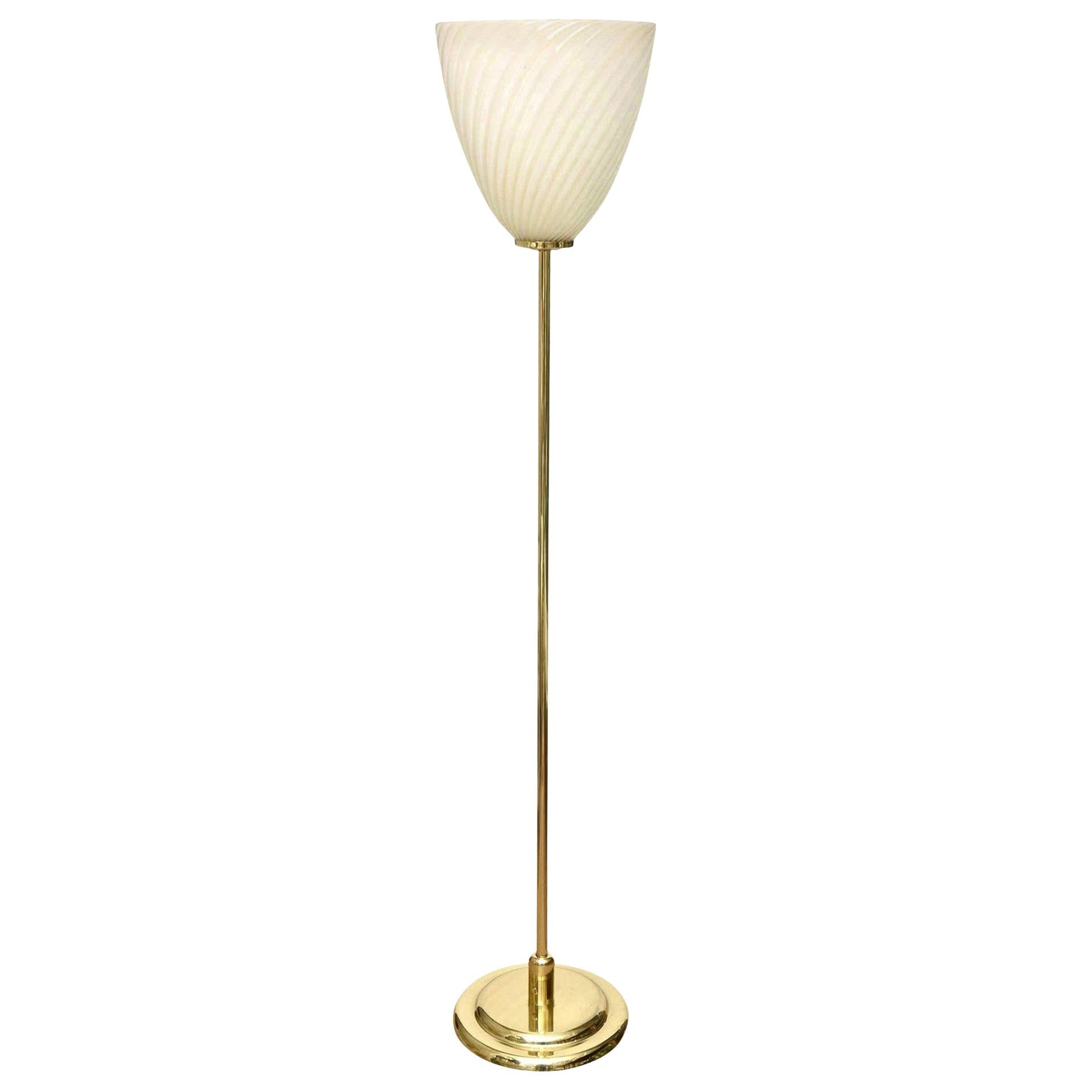 This Mid-Century Modern Italian Murano polished brass and glass floor lamp has a simplicity and elegance to it. It can go into any interior. The swirled hand blown original glass lamp shade has a beautiful warm romantic glow when lite as shown in