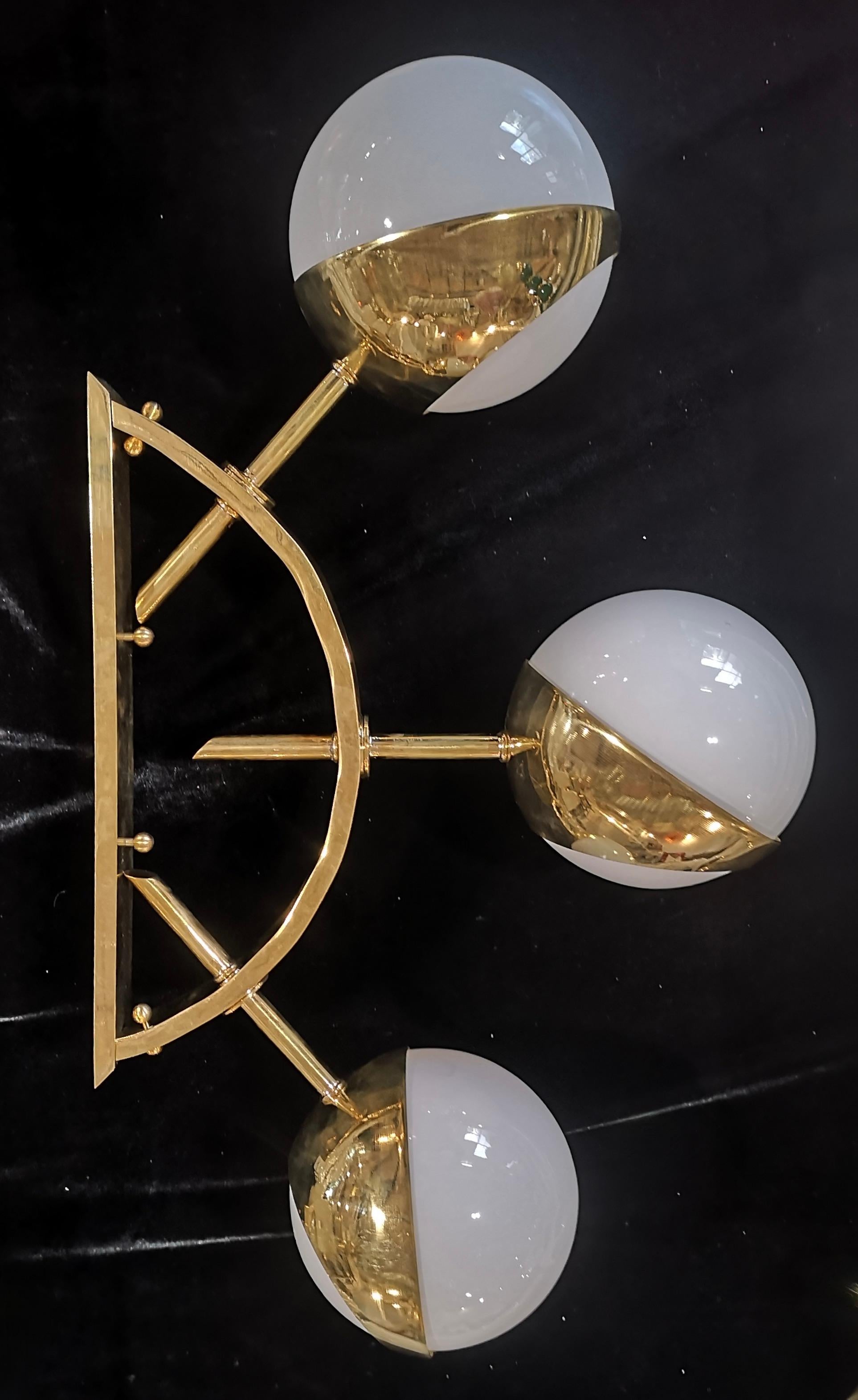 Unsurpassed design for this applique that features a triptych of lights along a beautiful brass arch. Unsurpassed Murano Design.

The wall lamp is composed of a very particular brass structure in the shape of an arch; brass arch from which three