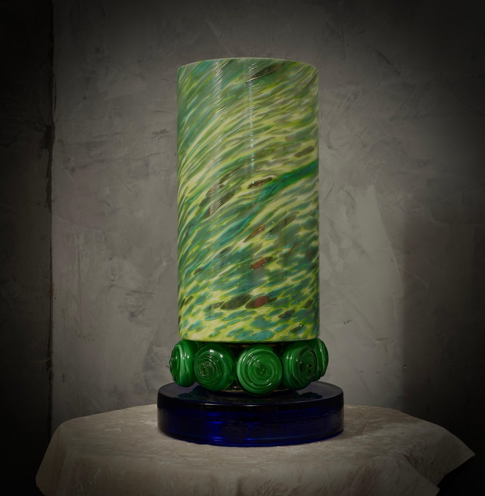 Précieux et unique verre blanc de Murano soufflé à la main, design classique mais original avec un fort contraste entre le grand vase vert et la base en verre bleu.

La lampe est caractérisée par un grand vase vert de forme cylindrique, avec un
