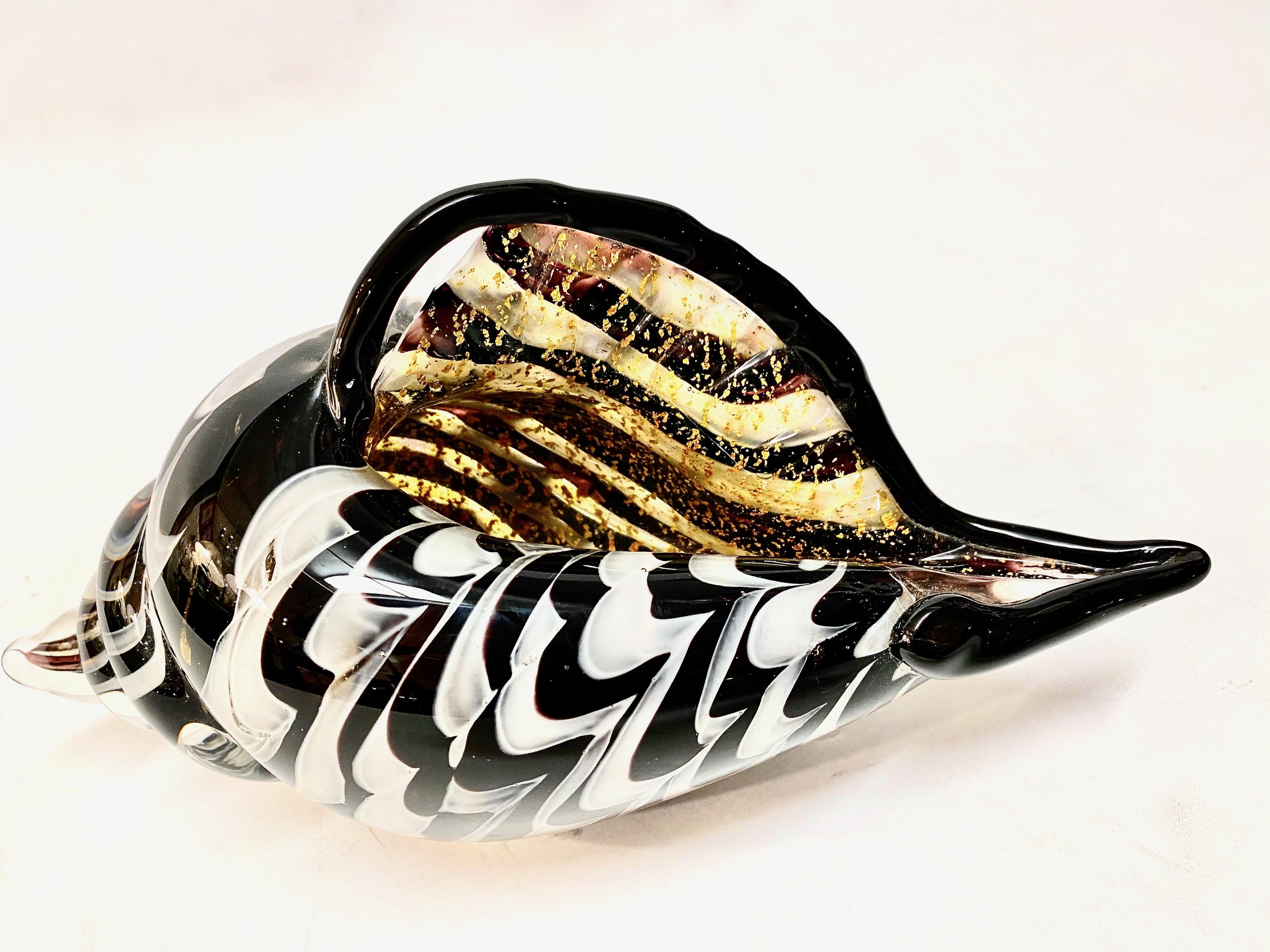 This is a good example of a c. 1960's Murano blown glass sea shell. The black and white design is highlighted by internal gold flecks. The large size of the shell together with the black & white contrasting glass makes this a very chic design
