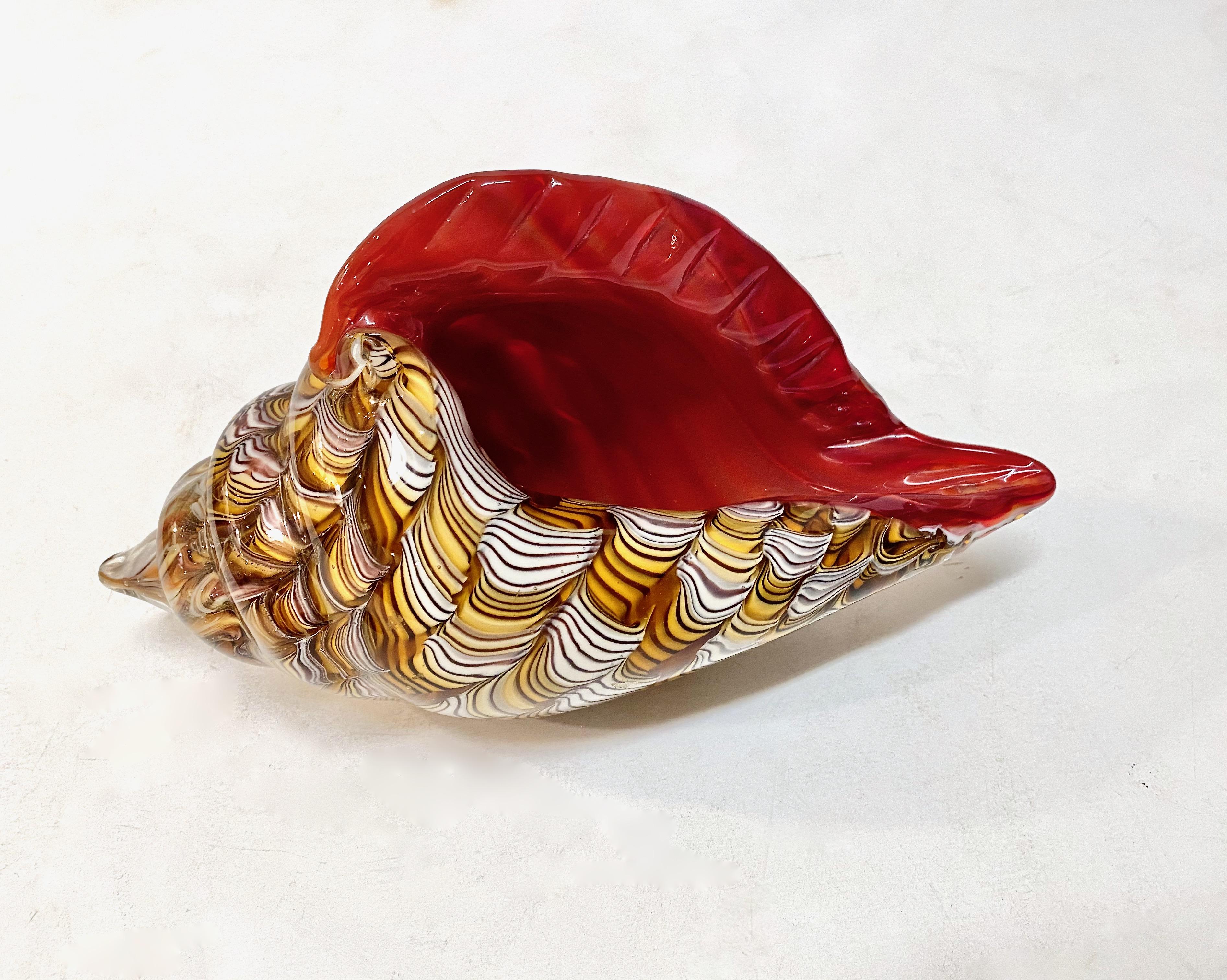 Beautiful mid-century Murano Shell sculpture or dish. This shell is beautifully designed with scrolls of toffee, honey and ivory cased in red glass. The impressive size of the shell combined with the positive energy of the multi-color design makes