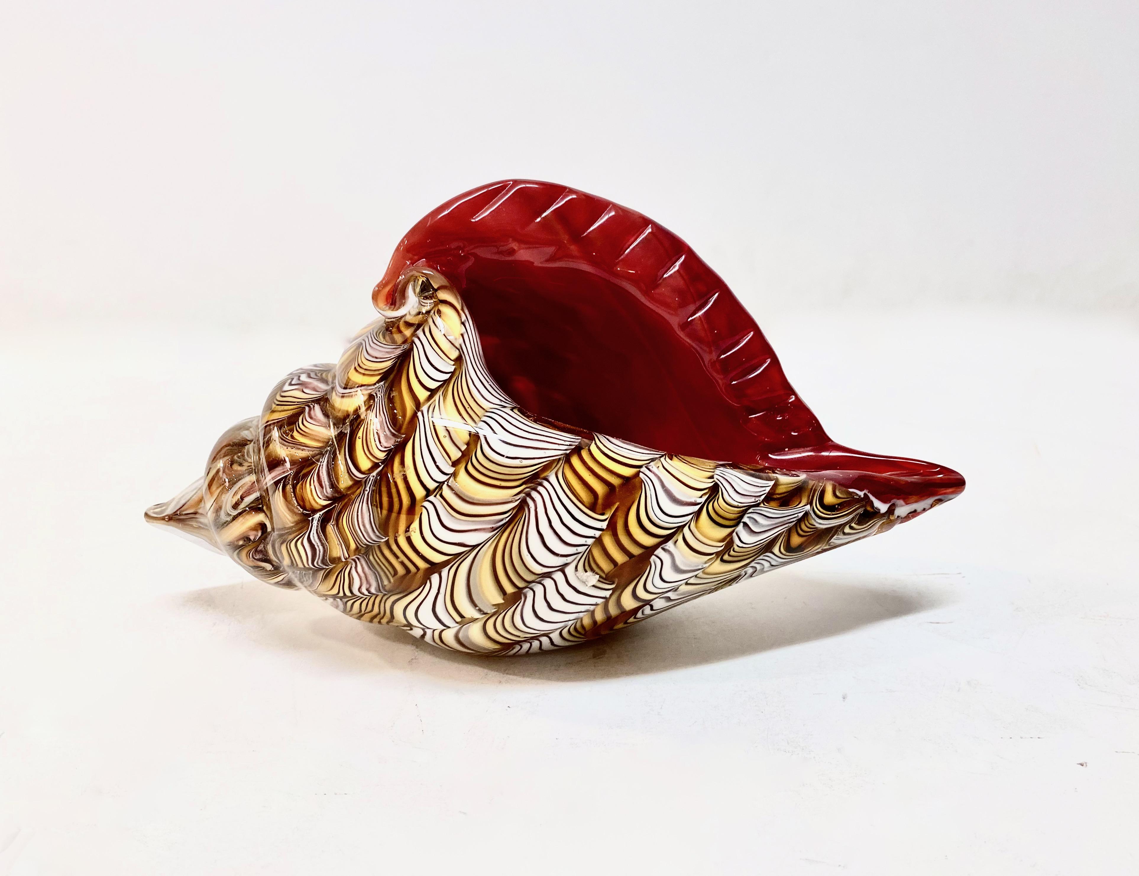 Bellissima scultura o piatto in conchiglia di Murano della metà del secolo scorso. Questa conchiglia è splendidamente disegnata con volute di mou, miele e avorio incastonate in vetro rosso. Le dimensioni impressionanti della conchiglia, combinate