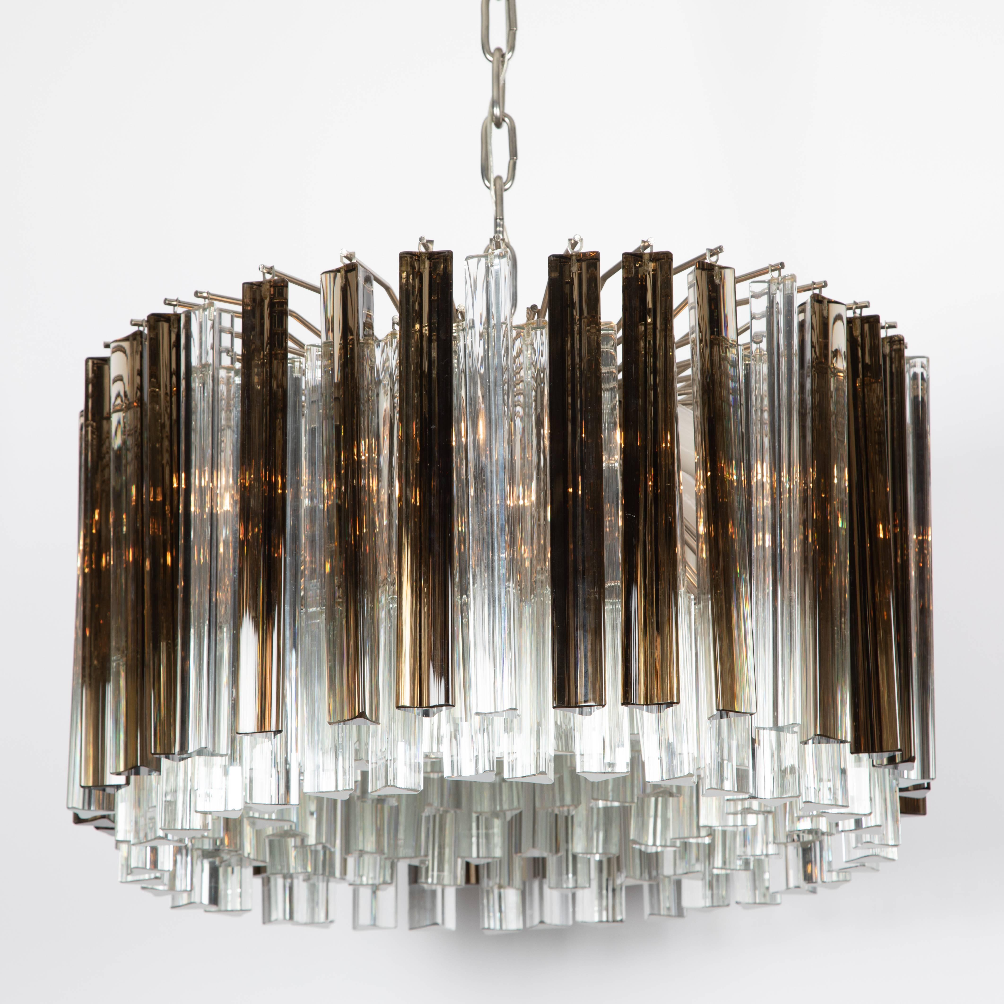 Fabulous 1970s Italian prism chandelier consisting of eight rings of densely spaced triangular crystals of two different lengths in a mixture of clear and smoked glass. Large and dramatic, this light will add sparkle to any setting. Brushed chrome