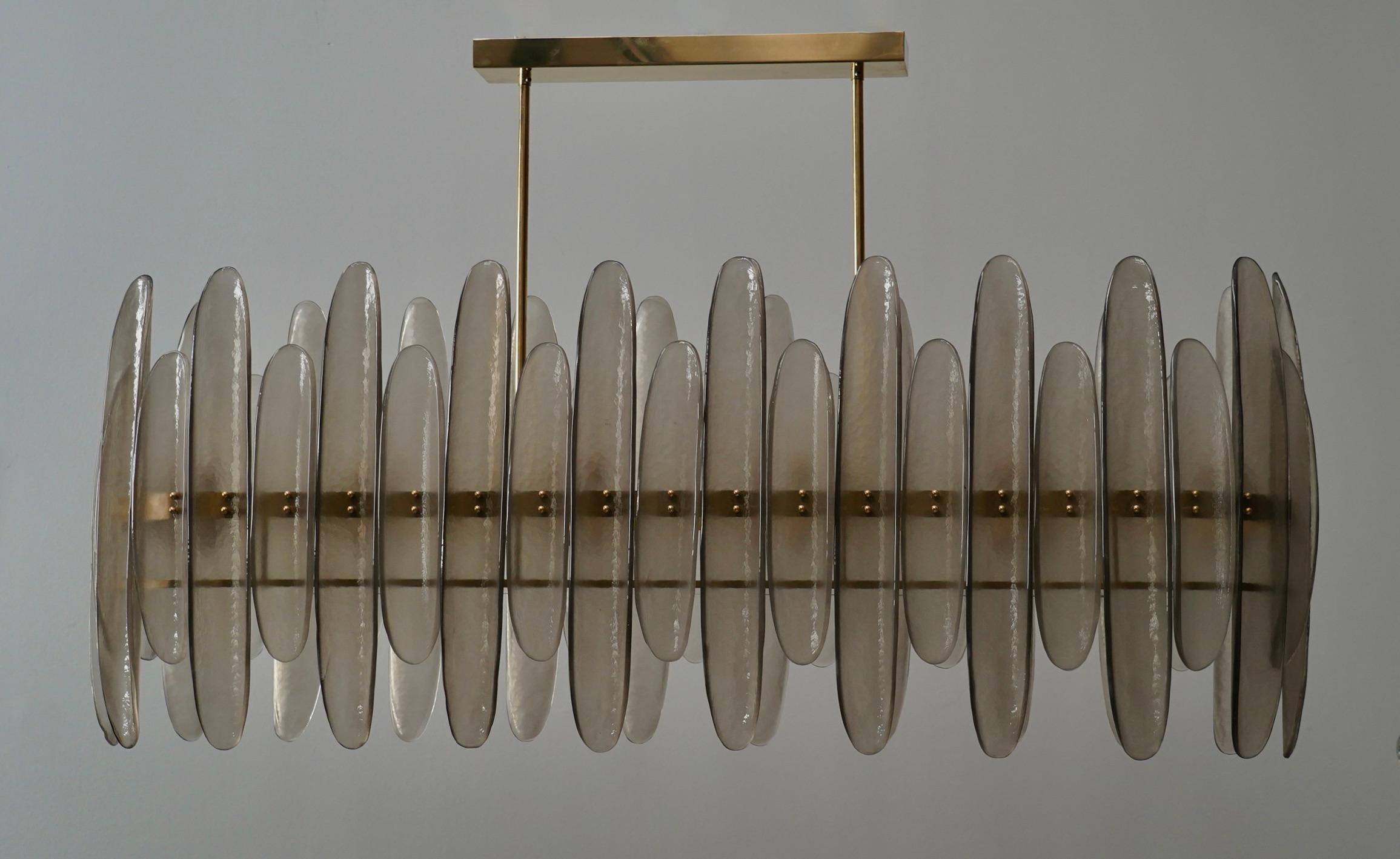 Murano chandelier with an elongated design, featuring a brass frame and single smoked glass. The glass half-shell is highly original and features a distinctive smoked color.

The chandelier has a rectangular brass frame, to which smoked glass