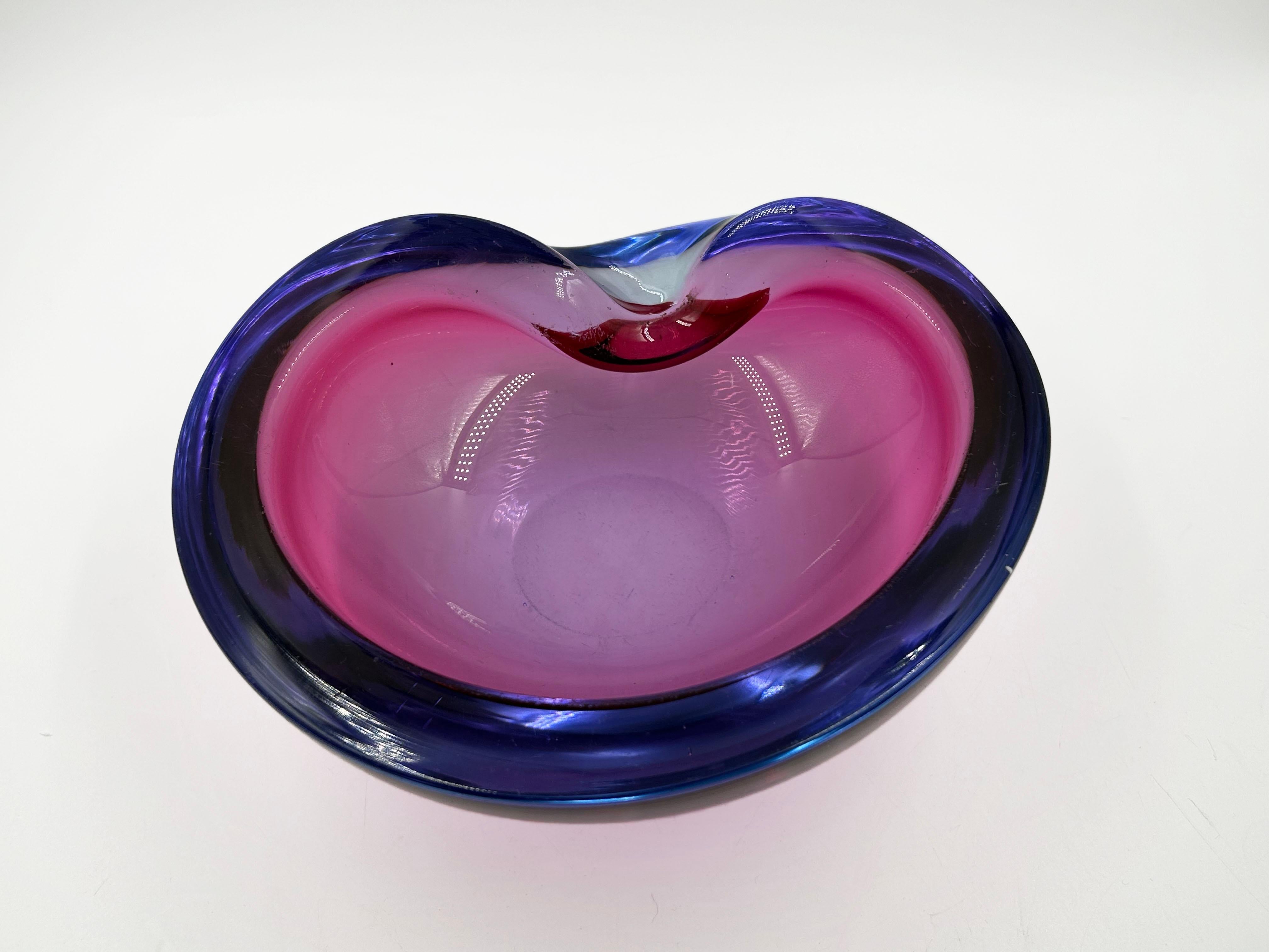 Murano Sommerso Ashtray from the 1960s
This Murano ashtray features an organic, asymmetrical shape, with a circular base and a wraparound design that rises at one end to create a functional resting place. The design is distinguished by the Sommerso