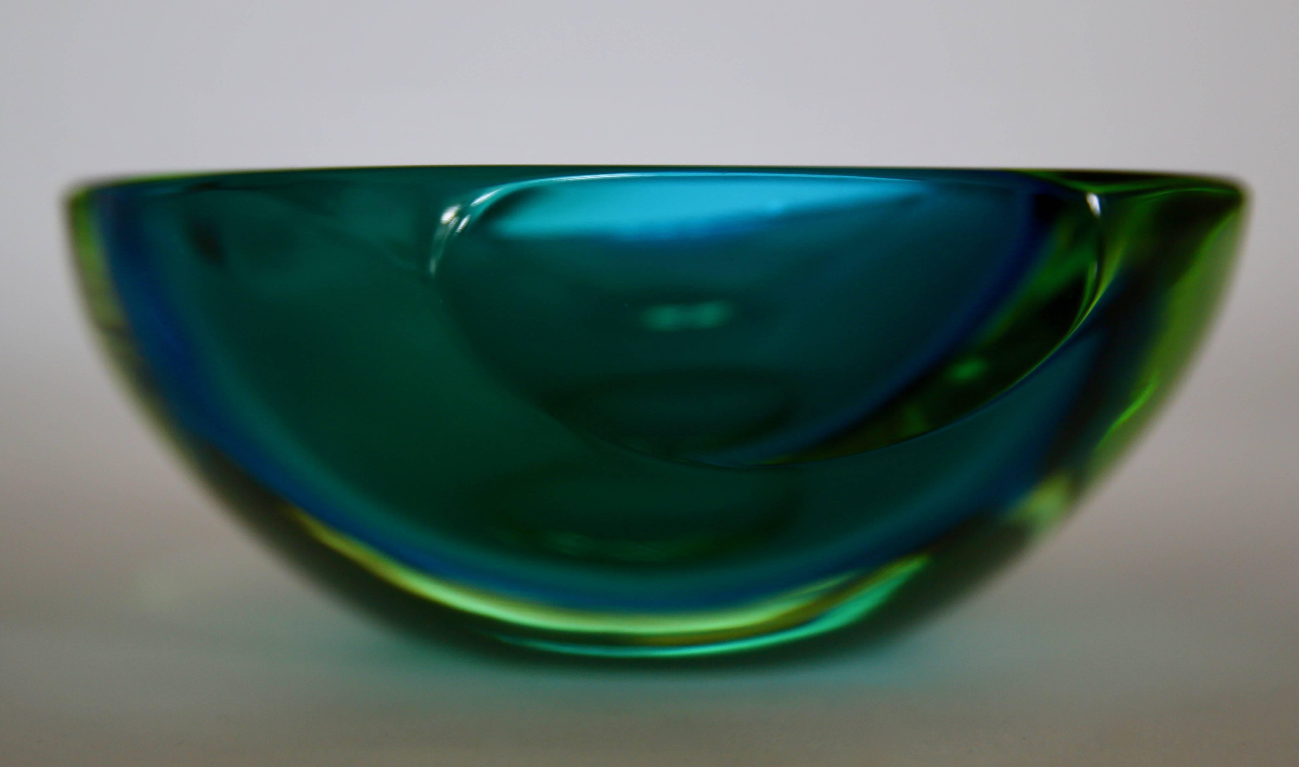 Murano Sommerso green and blue glass bowl, in absolutely excellent condition: no scratch, no loss: impeccable.
The brilliant colors of green and blue of this faceted flat cut polished glass Murano geode bowl is exquisite.
When light hits the bowl,