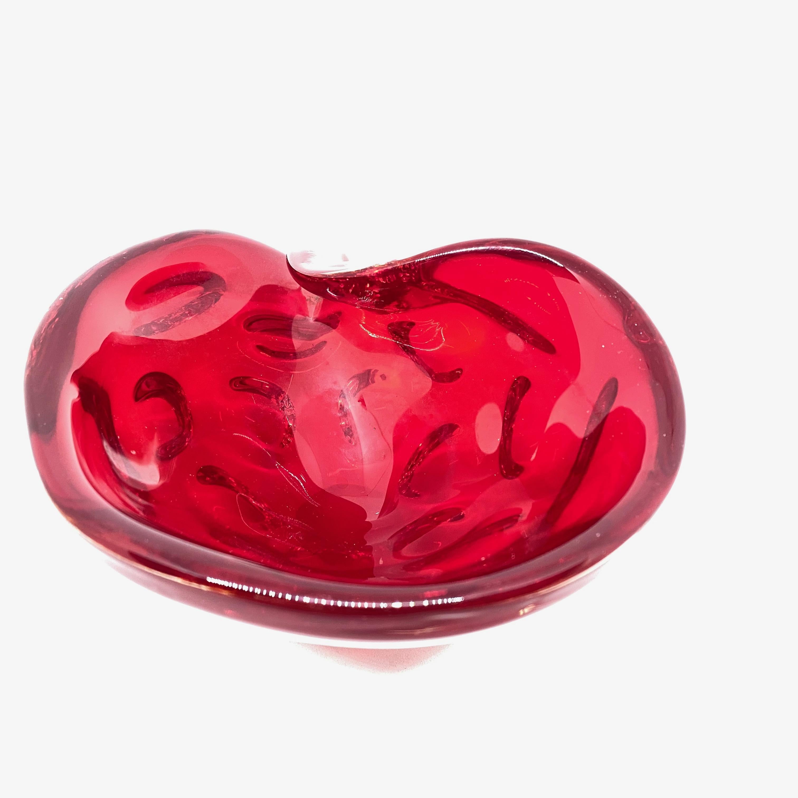 Gorgeous hand blown Murano art glass piece with Sommerso and bullicante techniques. A beautiful organic conch sea shell shaped bowl, catchall or ashtray in deep red, Italy, 1980s.