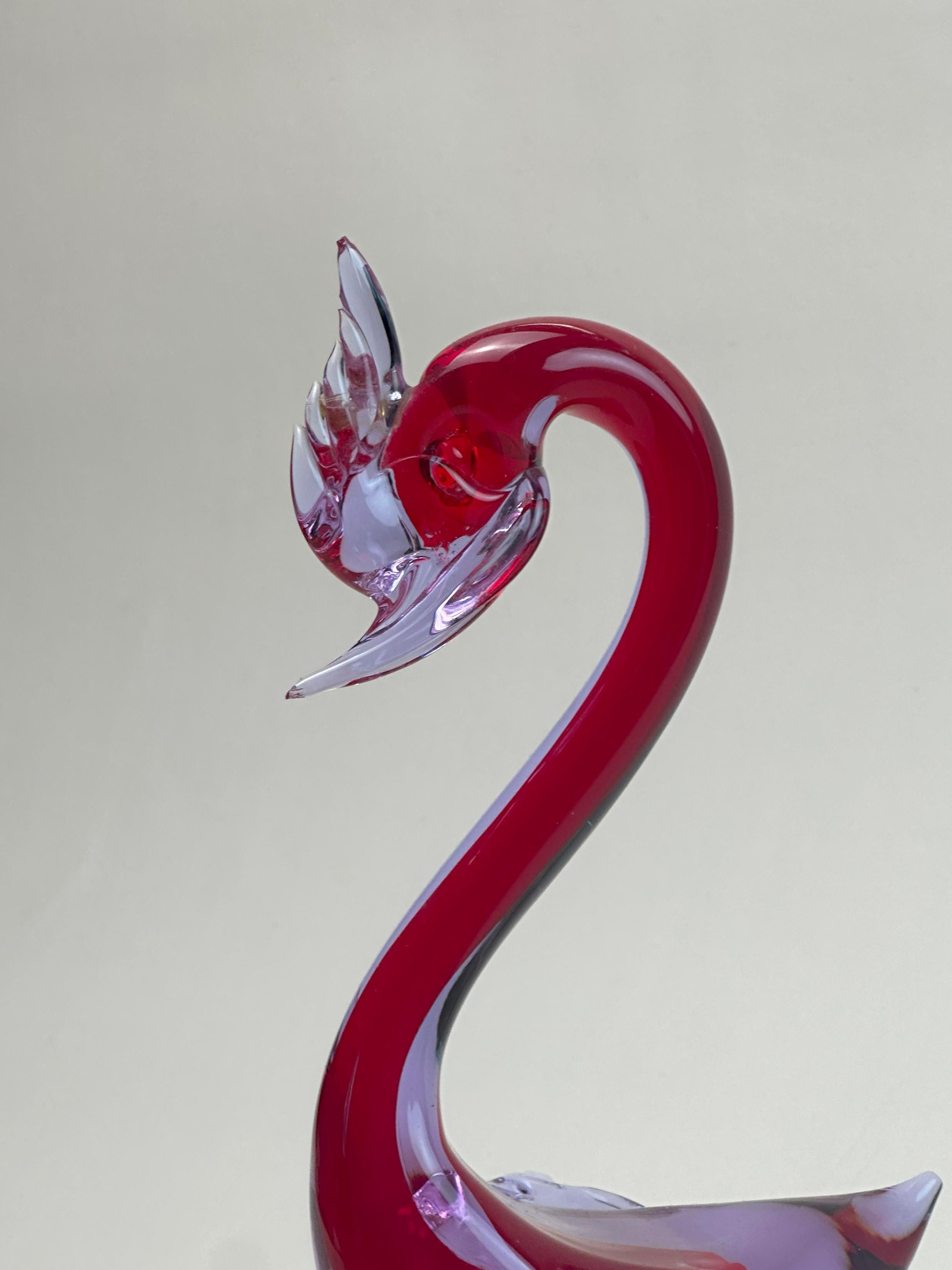 Sculpture de canard vintage en verre de Murano, attribuée au four de Fratelli Toso, et probablement produite pour l'exportation dans les années 1960. Formé à l'aide de la technique sommerso, un noyau rouge vif est enfermé dans une matrice lilas en