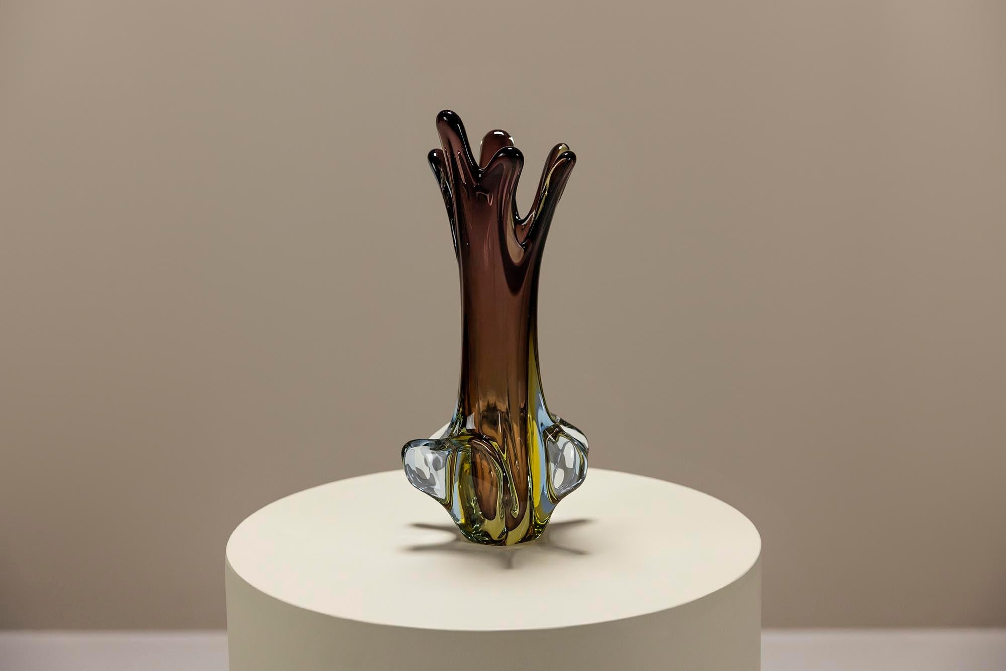 Questo vaso in vetro di Murano, realizzato dai rinomati Fratelli Toso, incarna la squisita arte e maestria per cui il vetro di Murano è celebrato. Il vaso presenta una forma fluida e organica con una straordinaria combinazione di colori, che fonde