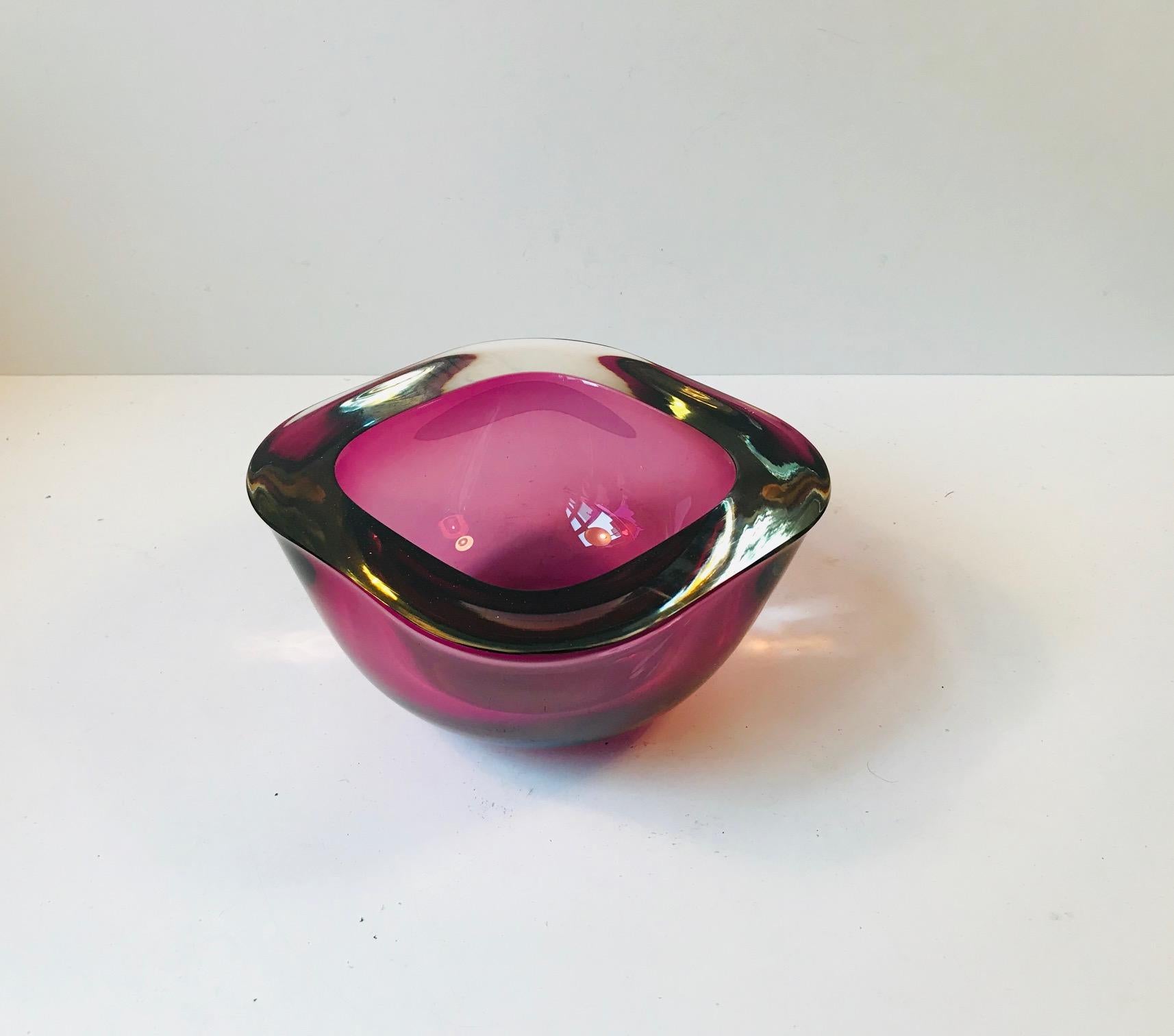 This heavy and thick decorative bowl is composed of purple cased Sommerso glass. It was designed by Flavio Poli in Murano, Italy, during the 1960s. Measures: Diameter 19 cm (7.5 inch).