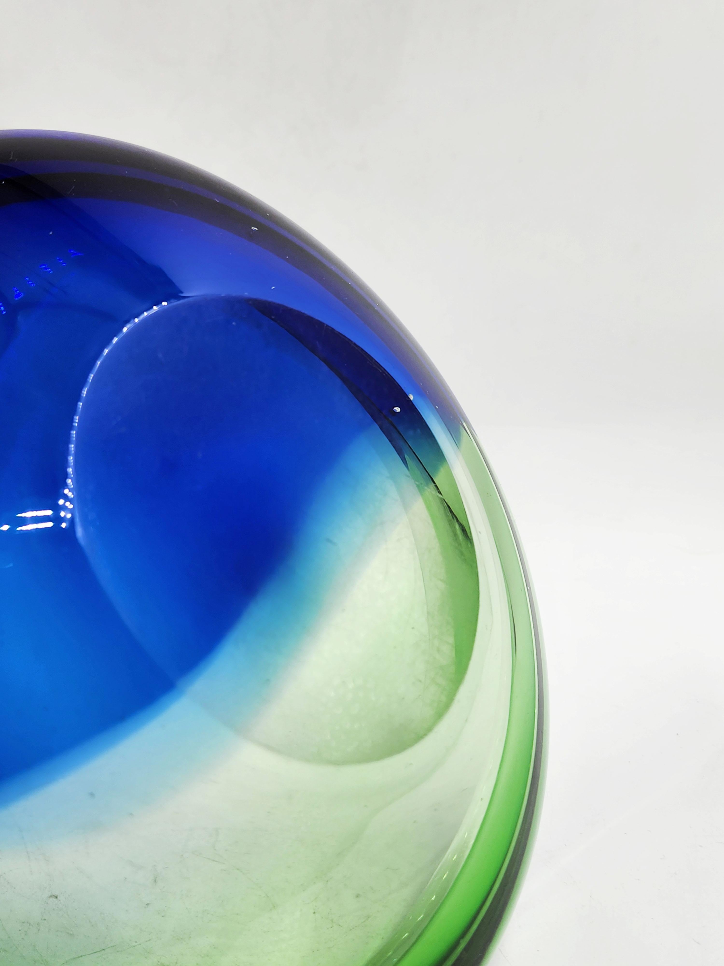 Venini's 1960s Sommerso Murano Glass Bowl
This exquisite Murano glass bowl, an authentic 1960s piece from the prestigious Venini house, captures the essence of Sommerso design with its play of colors and shapes. The Sommerso technique, which means
