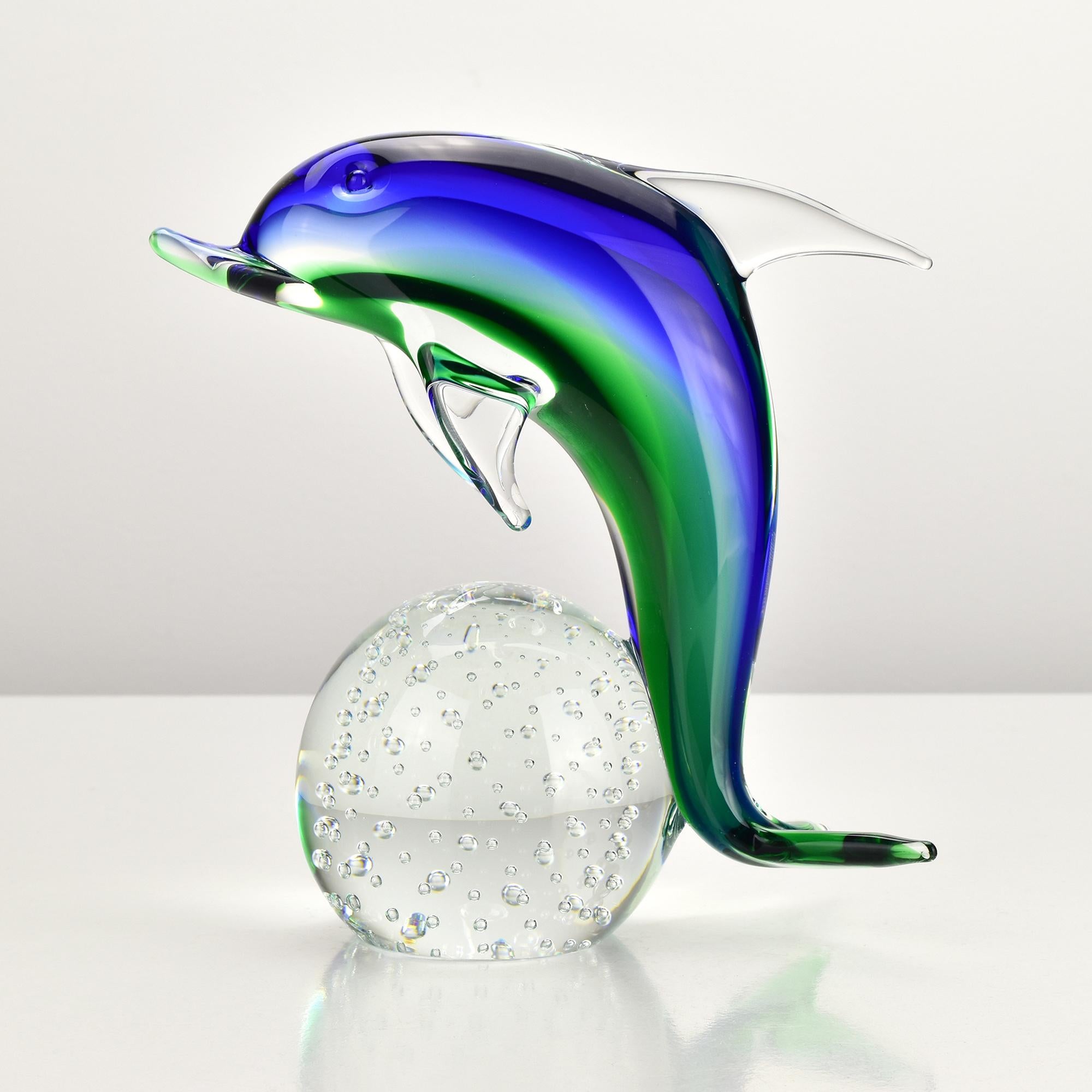 Élégante sculpture de dauphin en verre d'art de Murano attribuée à V.I.C., Italie, vers la fin du XXe siècle. Le dauphin présente des teintes vibrantes de bleu cobalt et de vert émeraude, mélangées de façon magistrale selon la technique du sommerso.